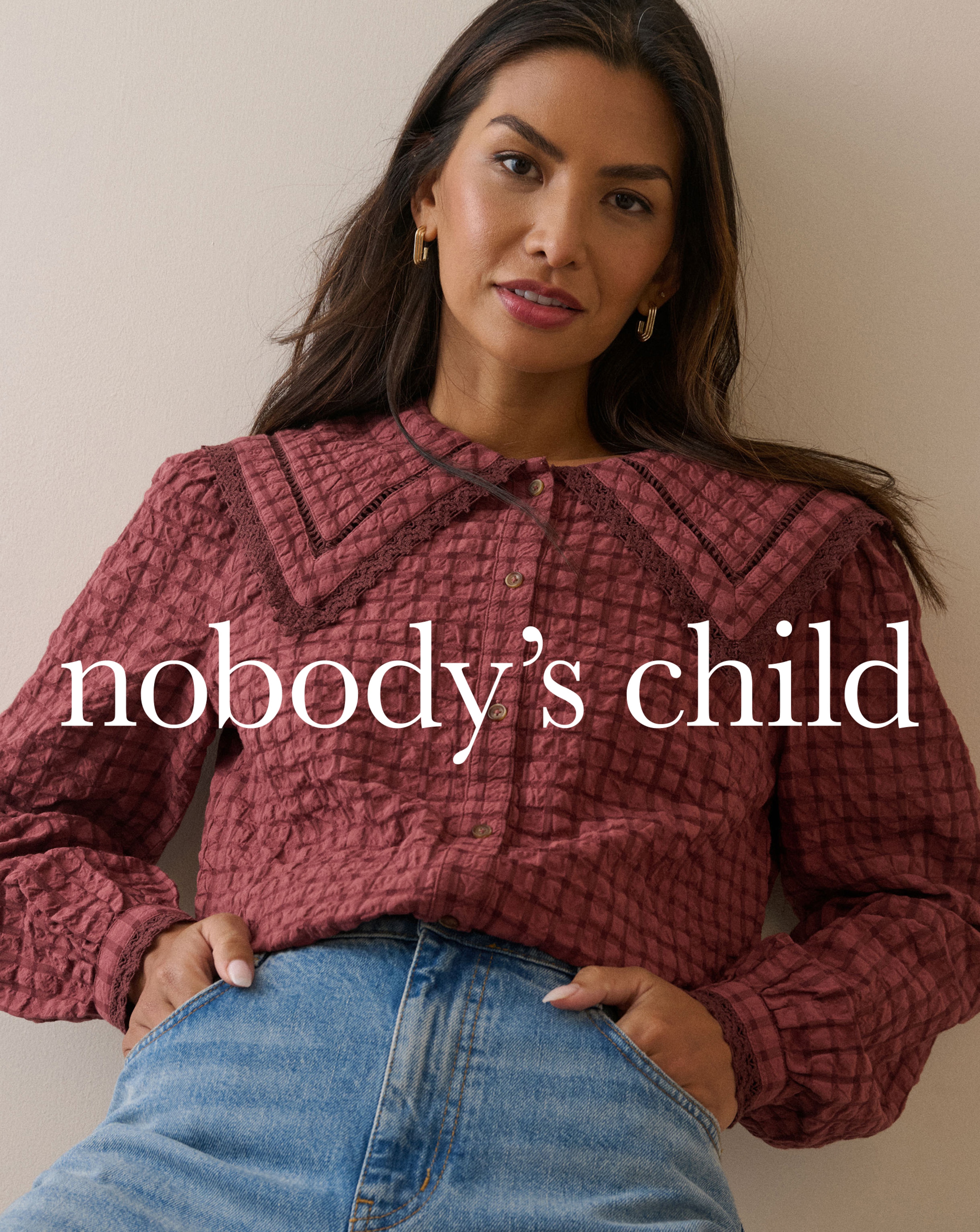 A woman wearing a maroon Nobody's Child blouse