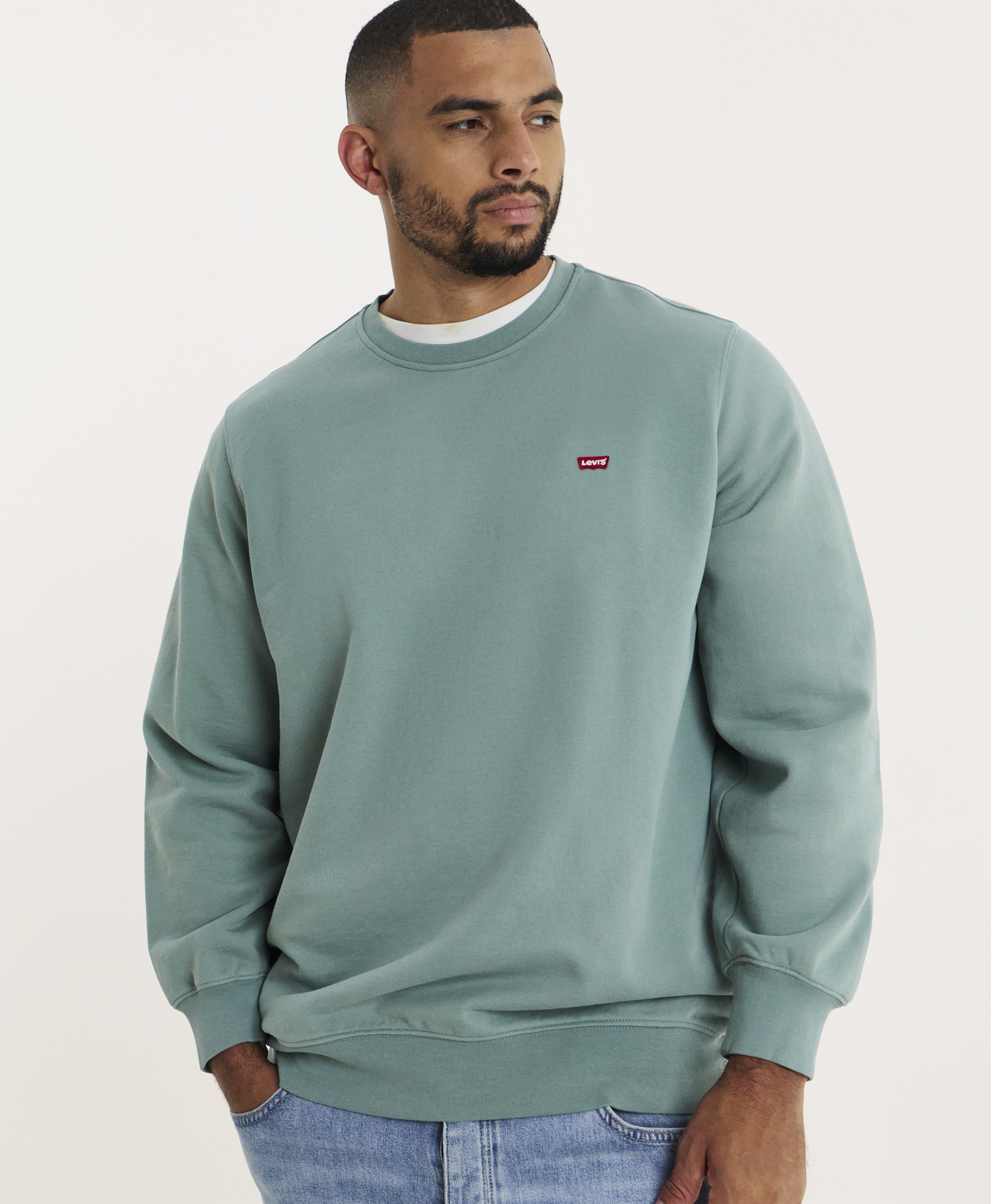 A man wearing a sage green Levi's jumper.