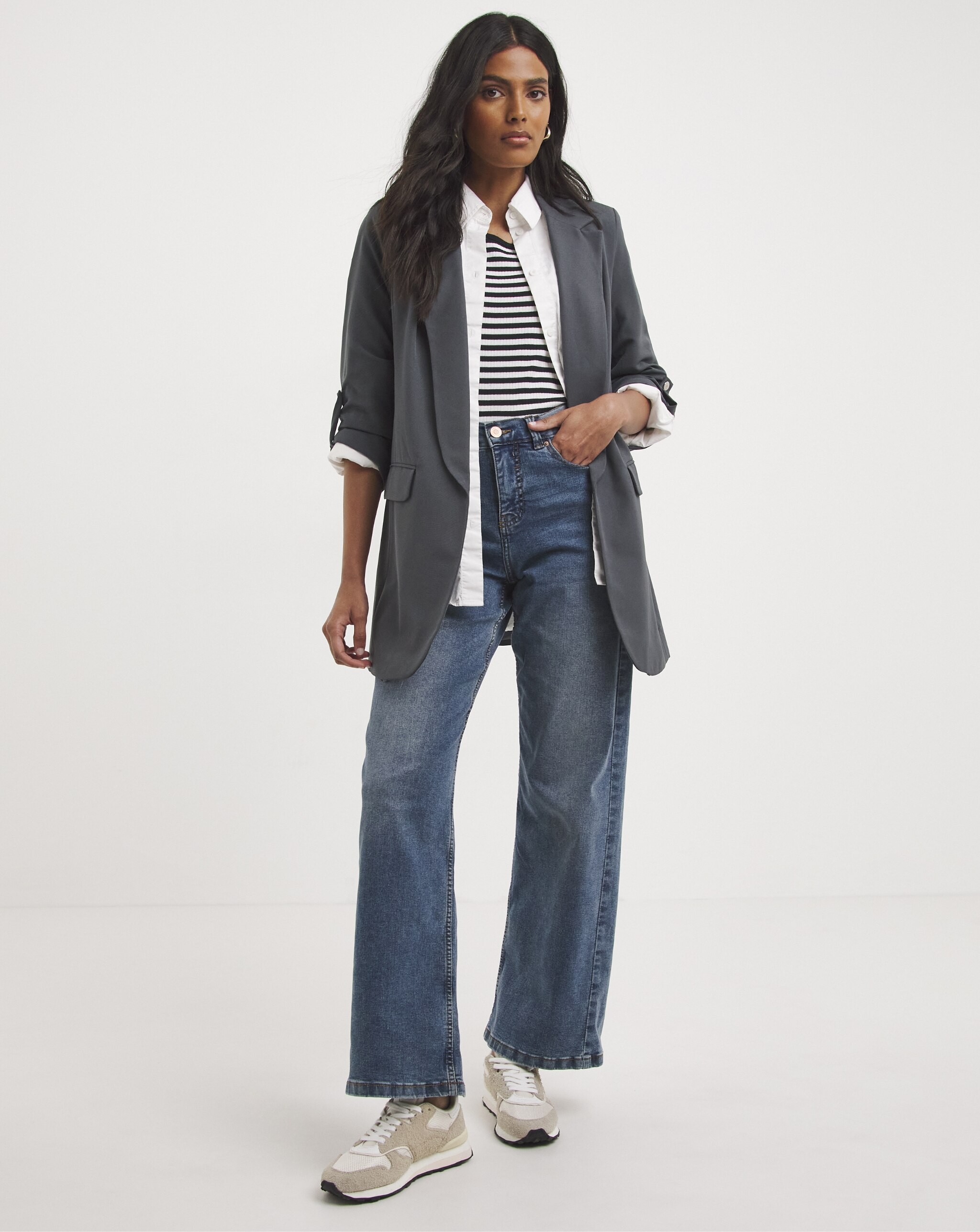 Womanwearing grey slate jacket, white shirt and denim jeans