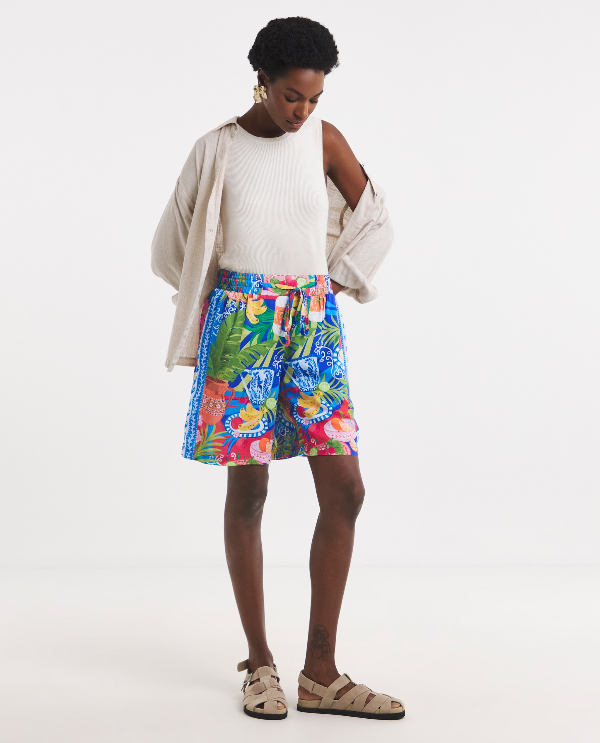 Model wears linen shirt and print shorts