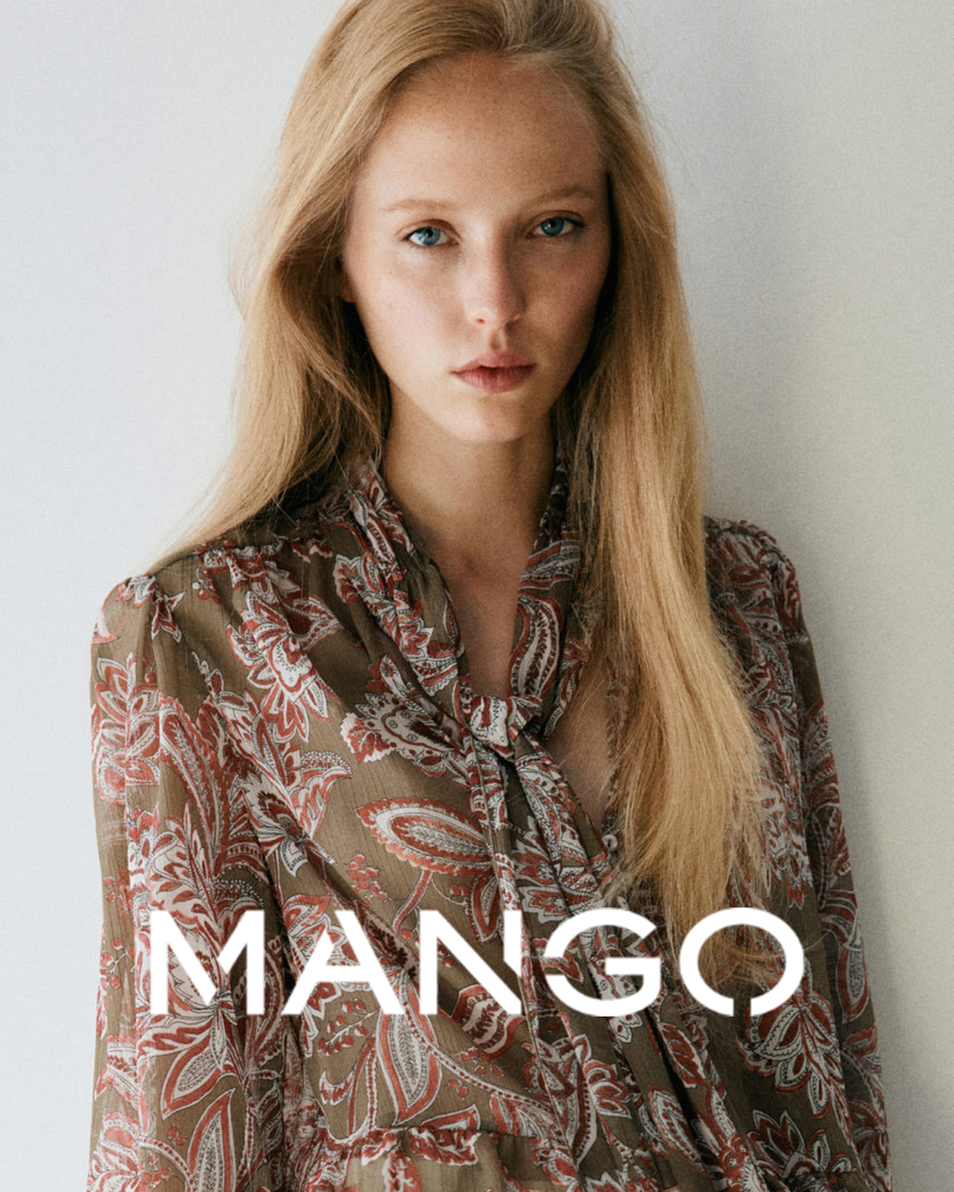 A woman wearing a brown floral print Mango top.
