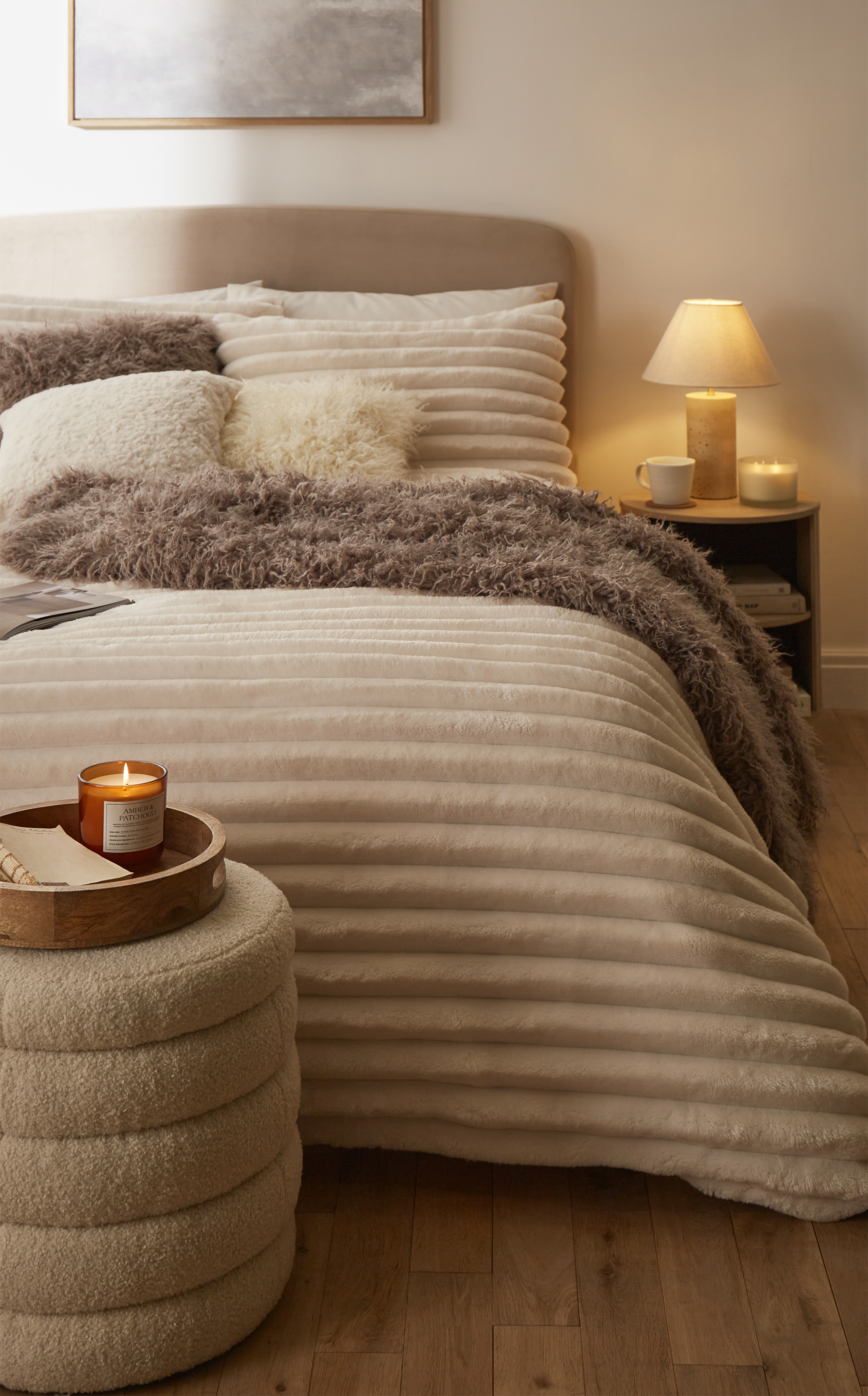 A bedroom with a beige and light brown fleece bed throw.