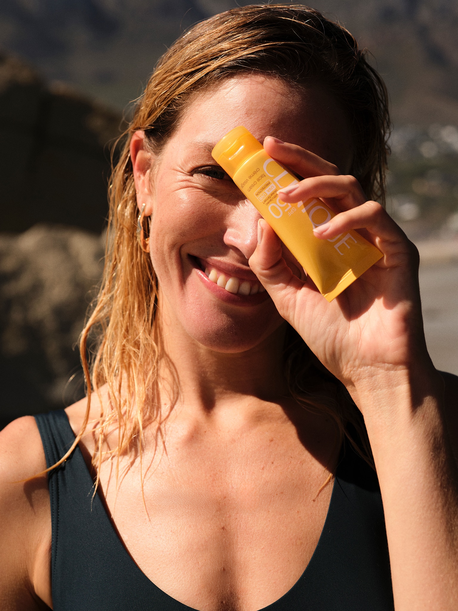 Woman in swimsuit holding suncream