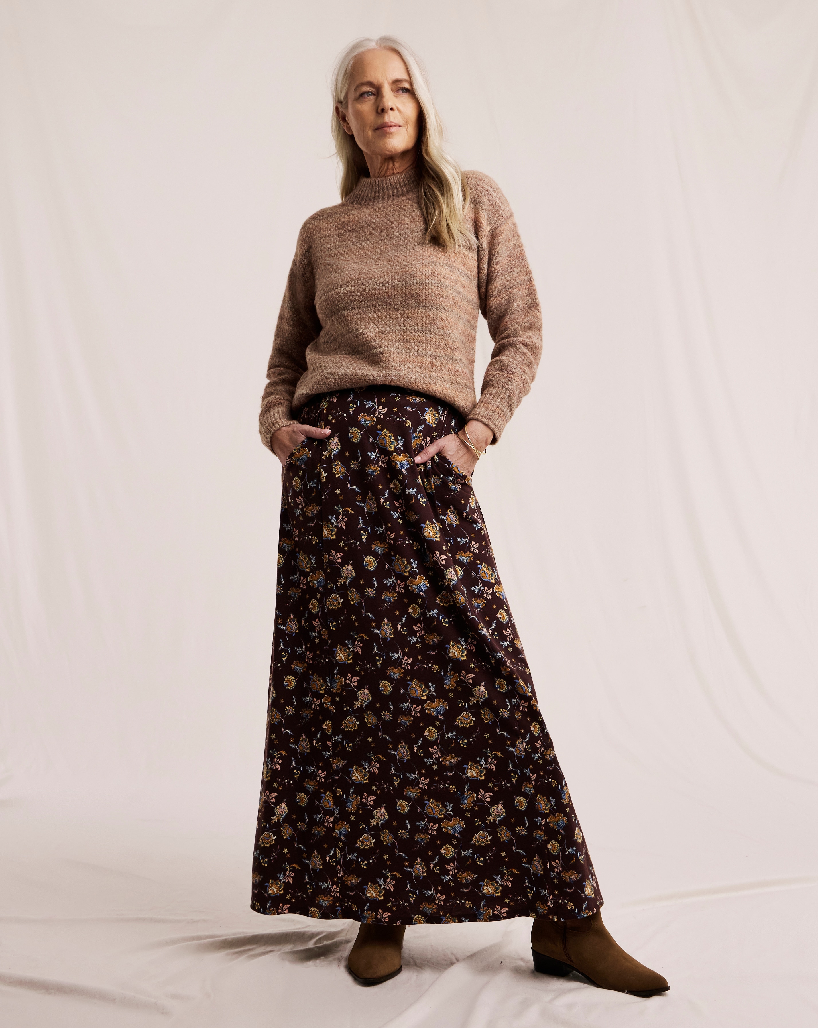 Mature woman in brown sweater and dark floral midi skirt