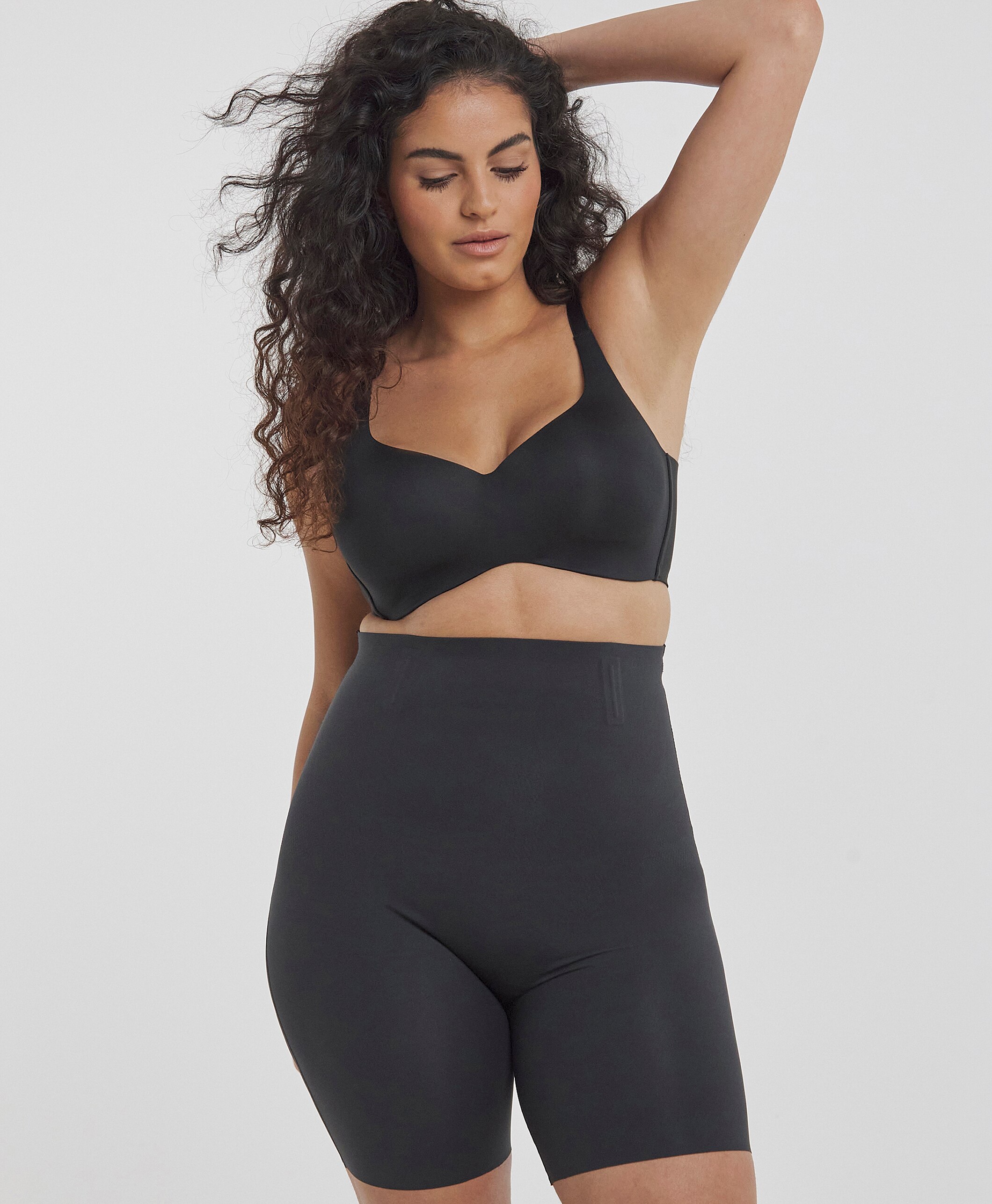 A lady wearing MAGISCULPT Medium Control Smooth & Sculpt Thigh Shaper Black