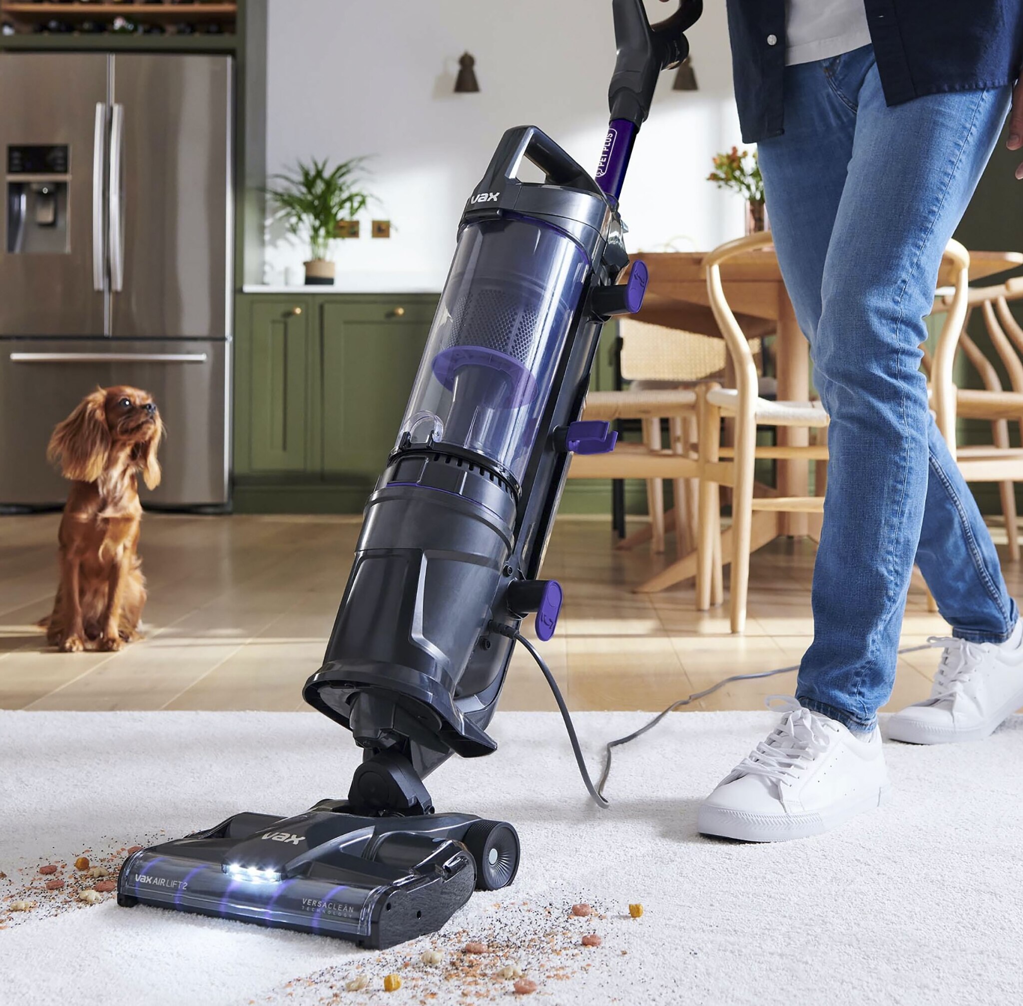 A woman using a VAX Upright vacuum  cleaner