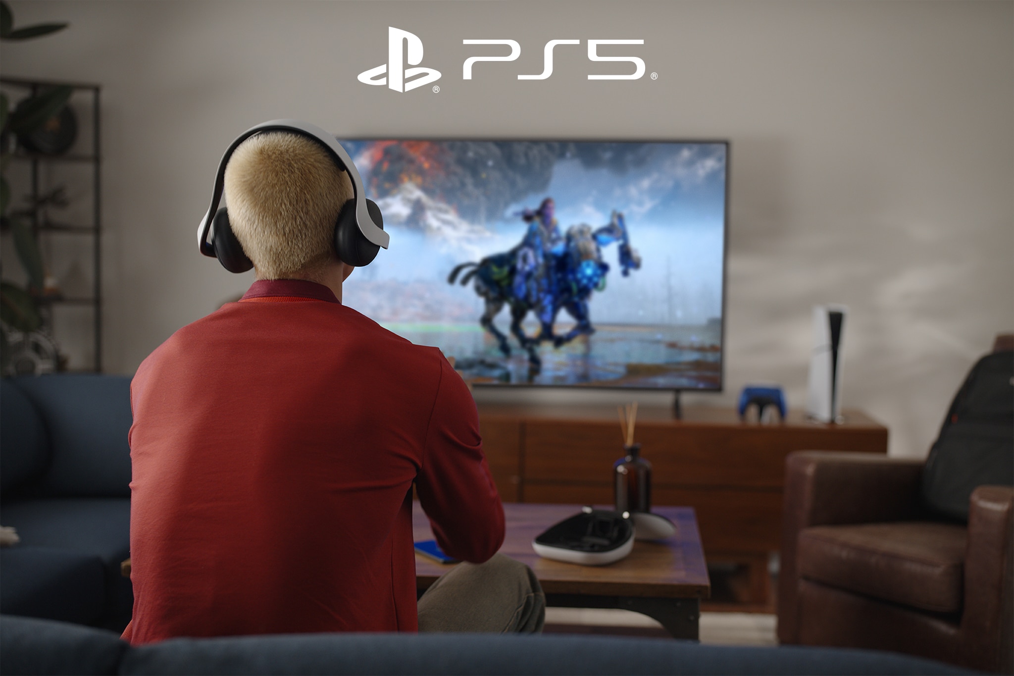 Person wearing an orange top playing a PlayStation®5 game.