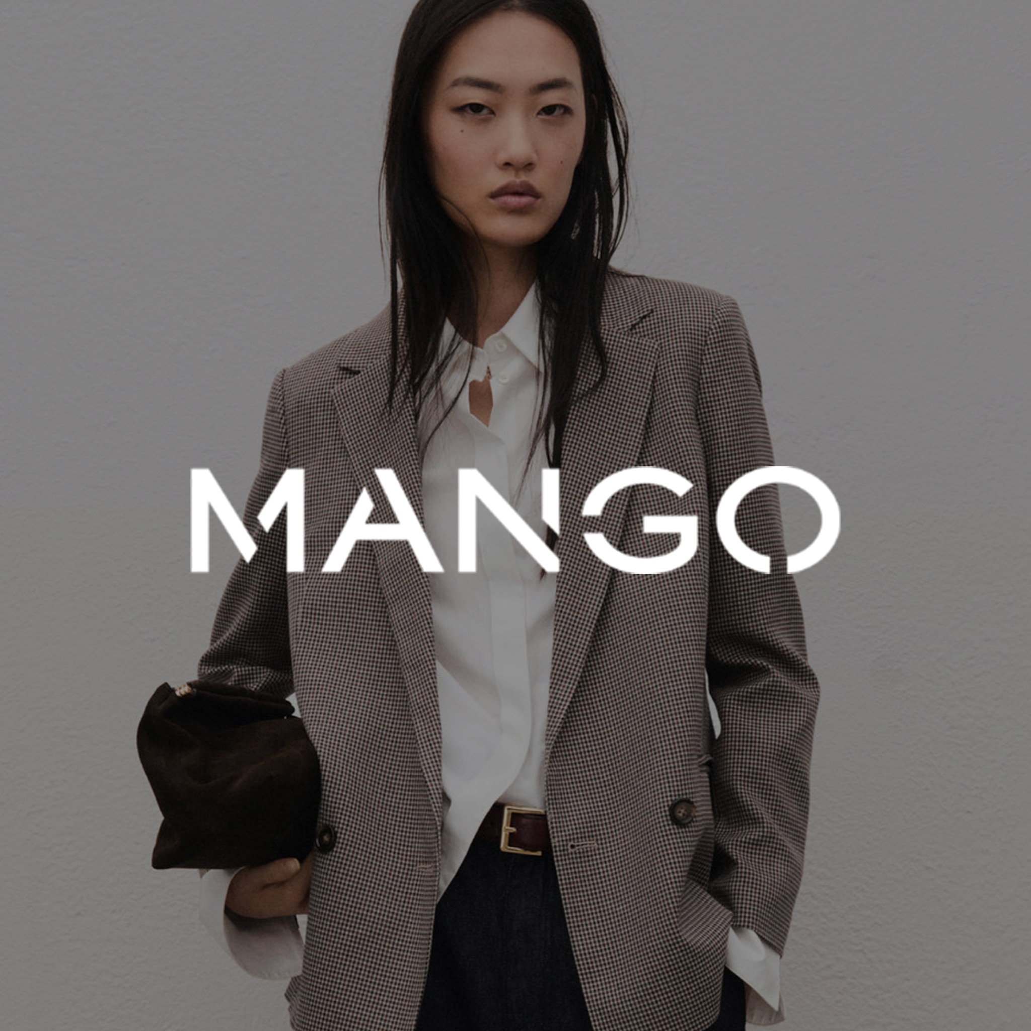A lady wearing a Mango Blazer and white shirt. The Mango logo is overlaid on the image