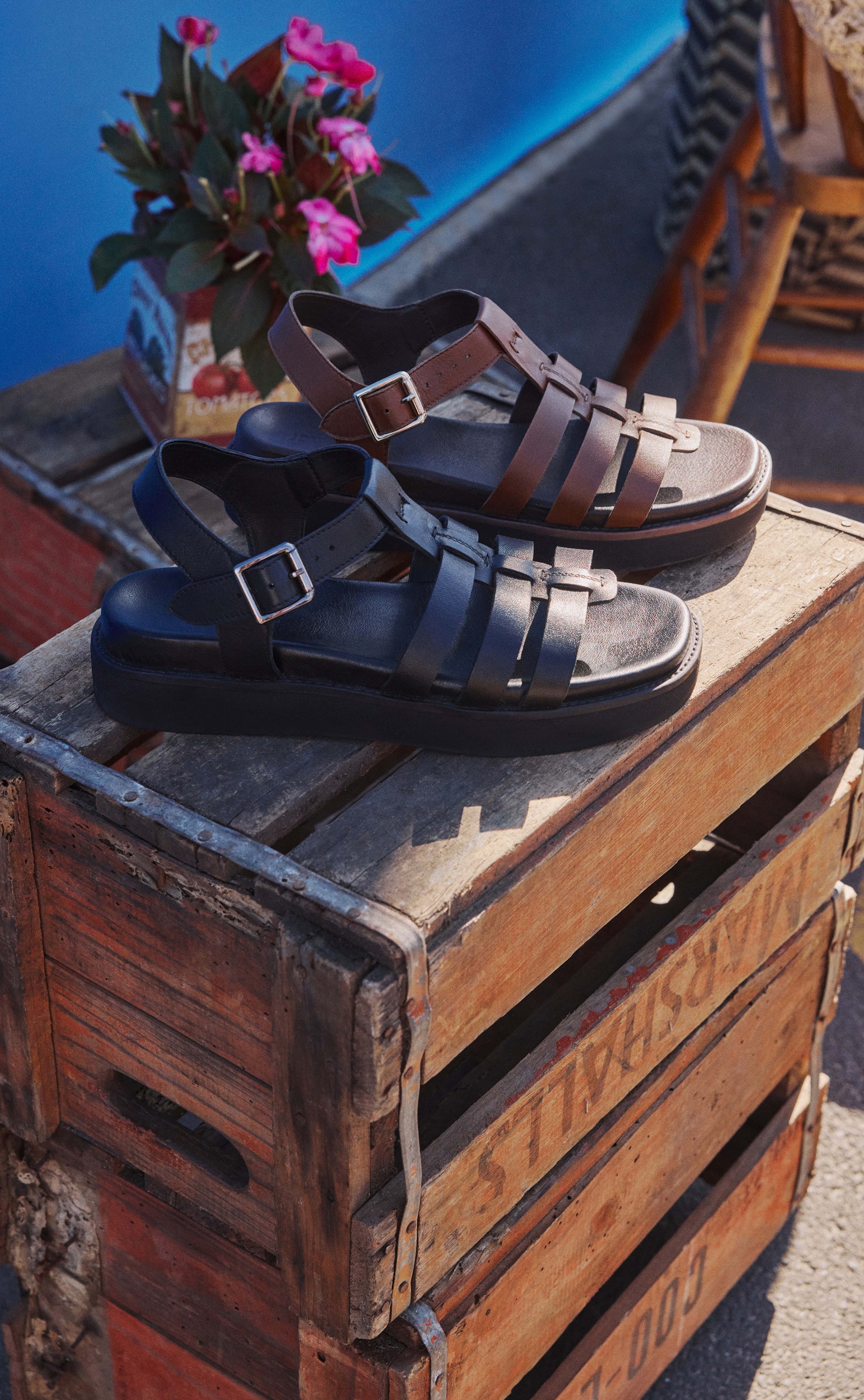 Sandals in two different colours on a wooden box