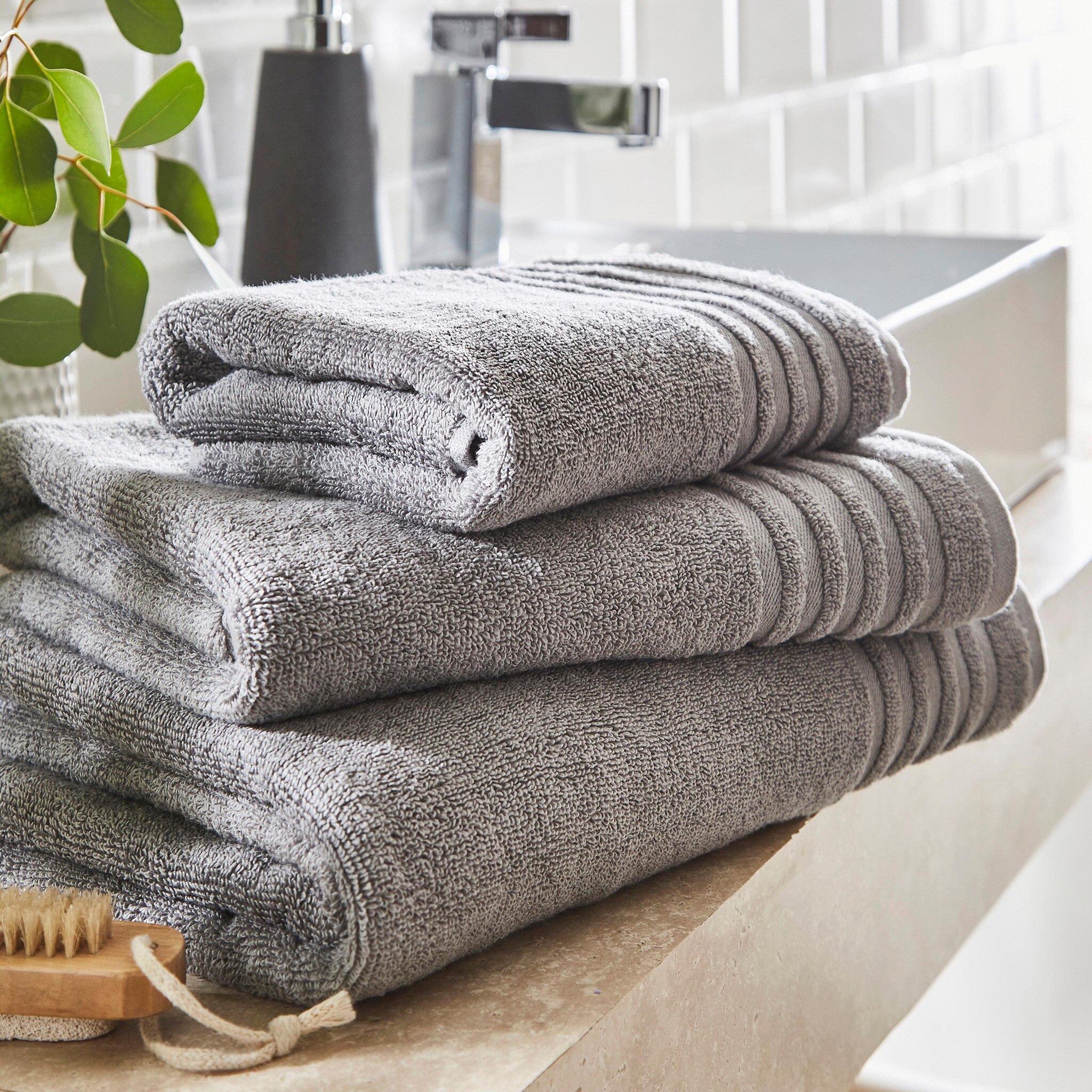 Grey towels and a soap dispenser