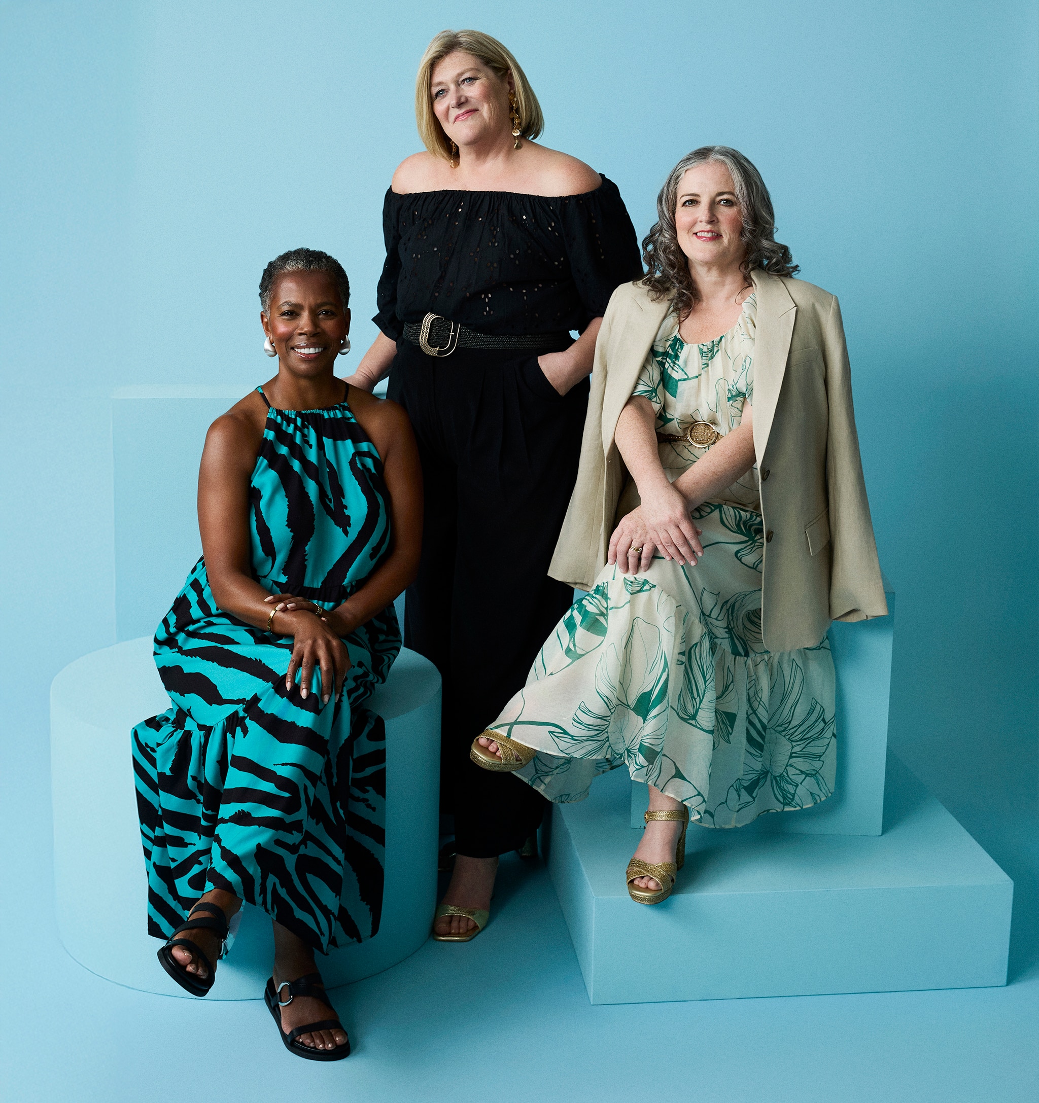 3 ladies on a photo shoot in a blue studio.
