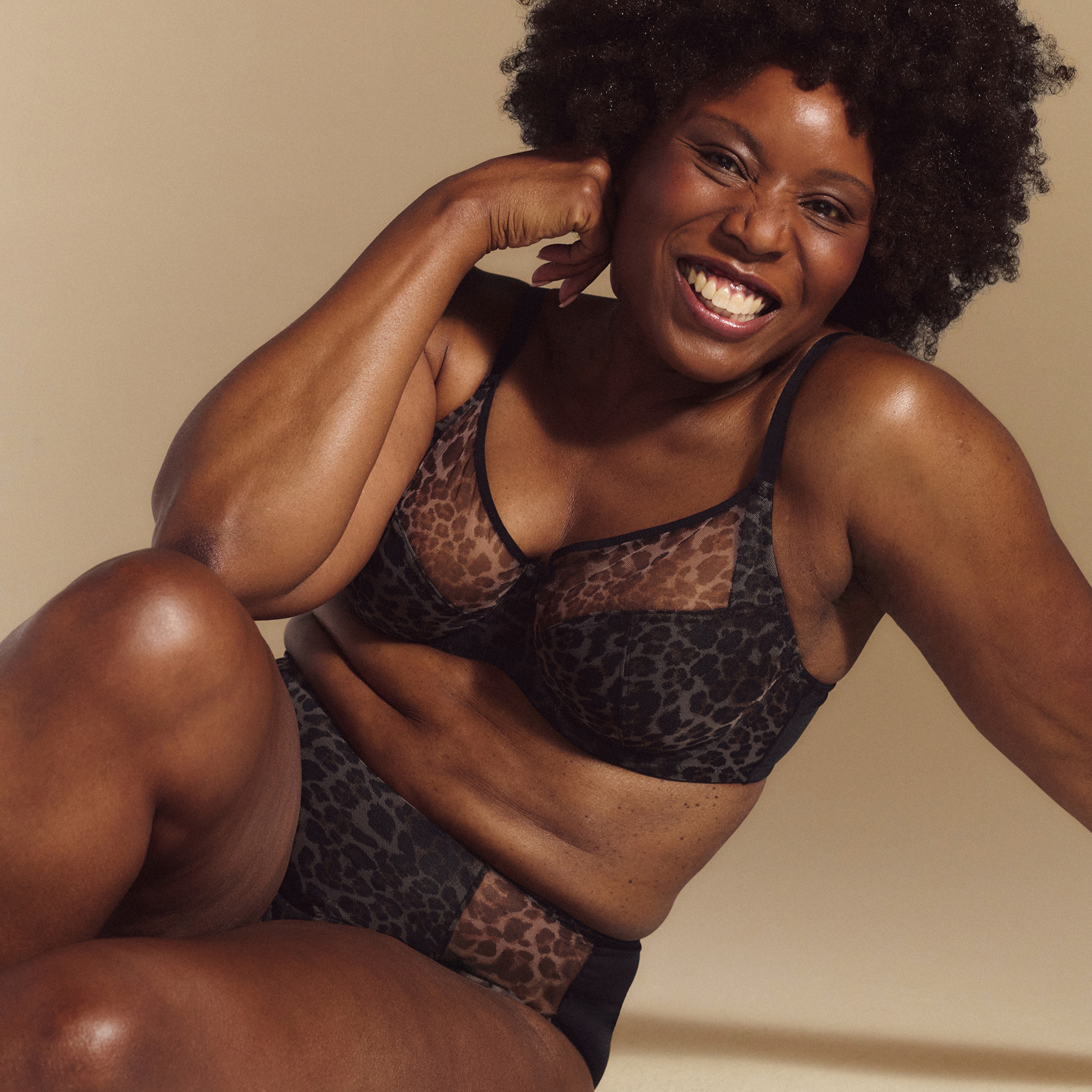 A lady sat down on the floor wearing black matching lingerie.