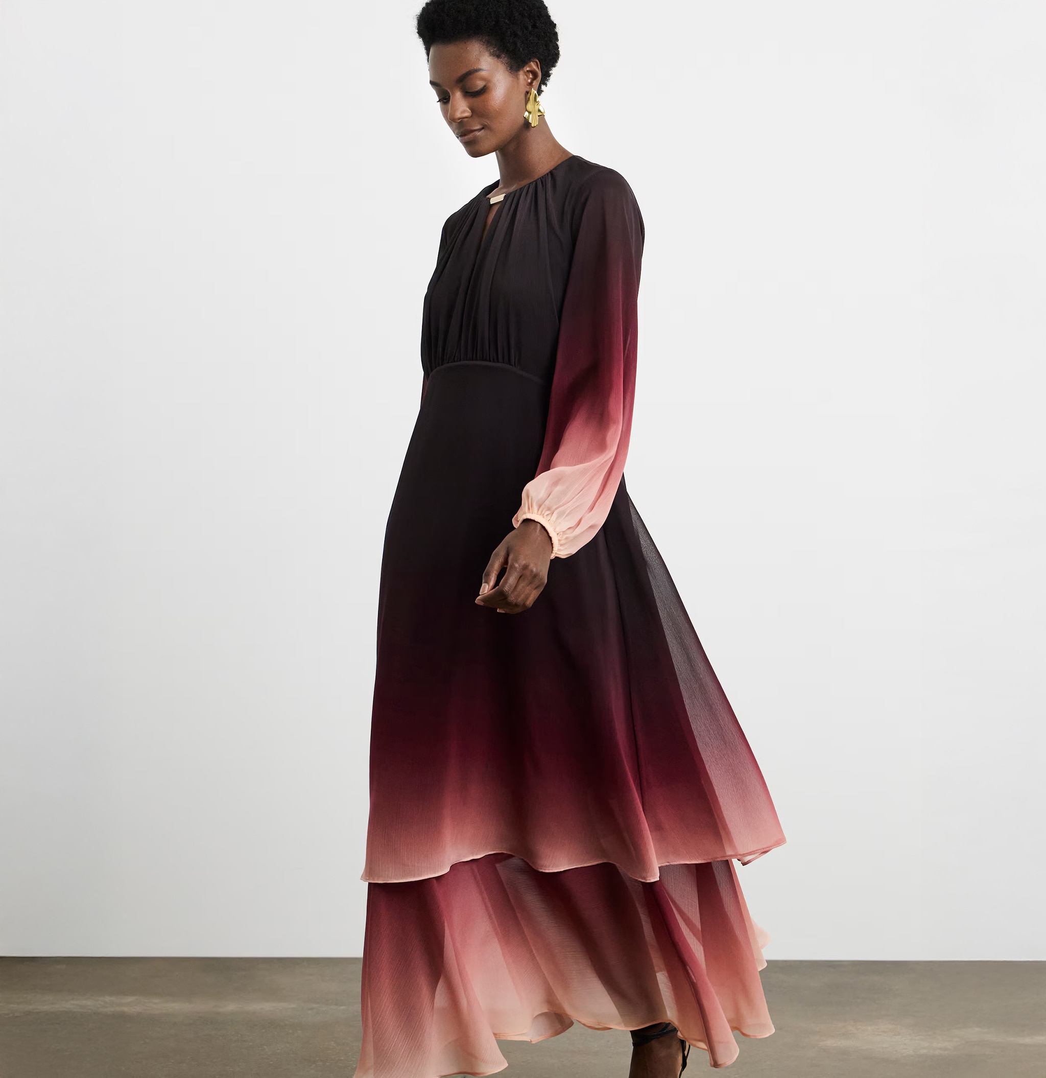 A lady walking to the left wearing a Joanna Hope ombre tiered maxi dress
