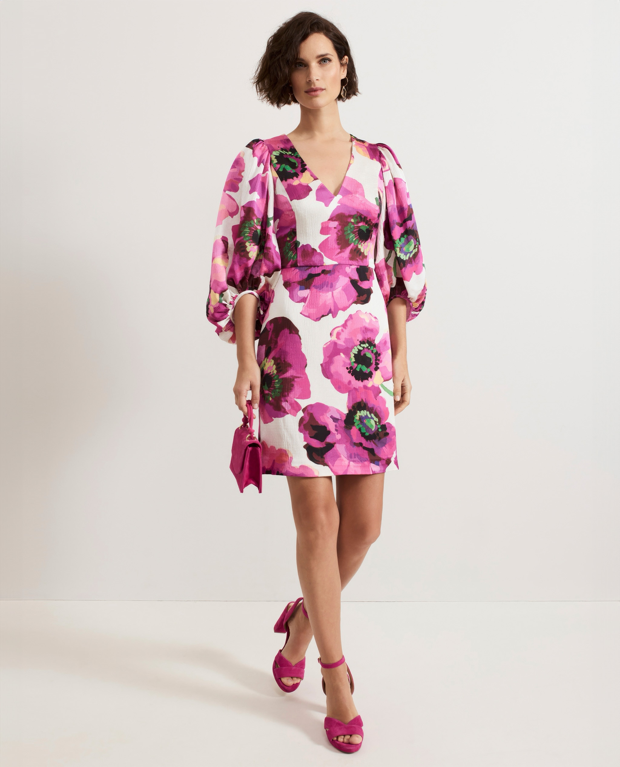 Model wearing a bright pink floral print mini dress