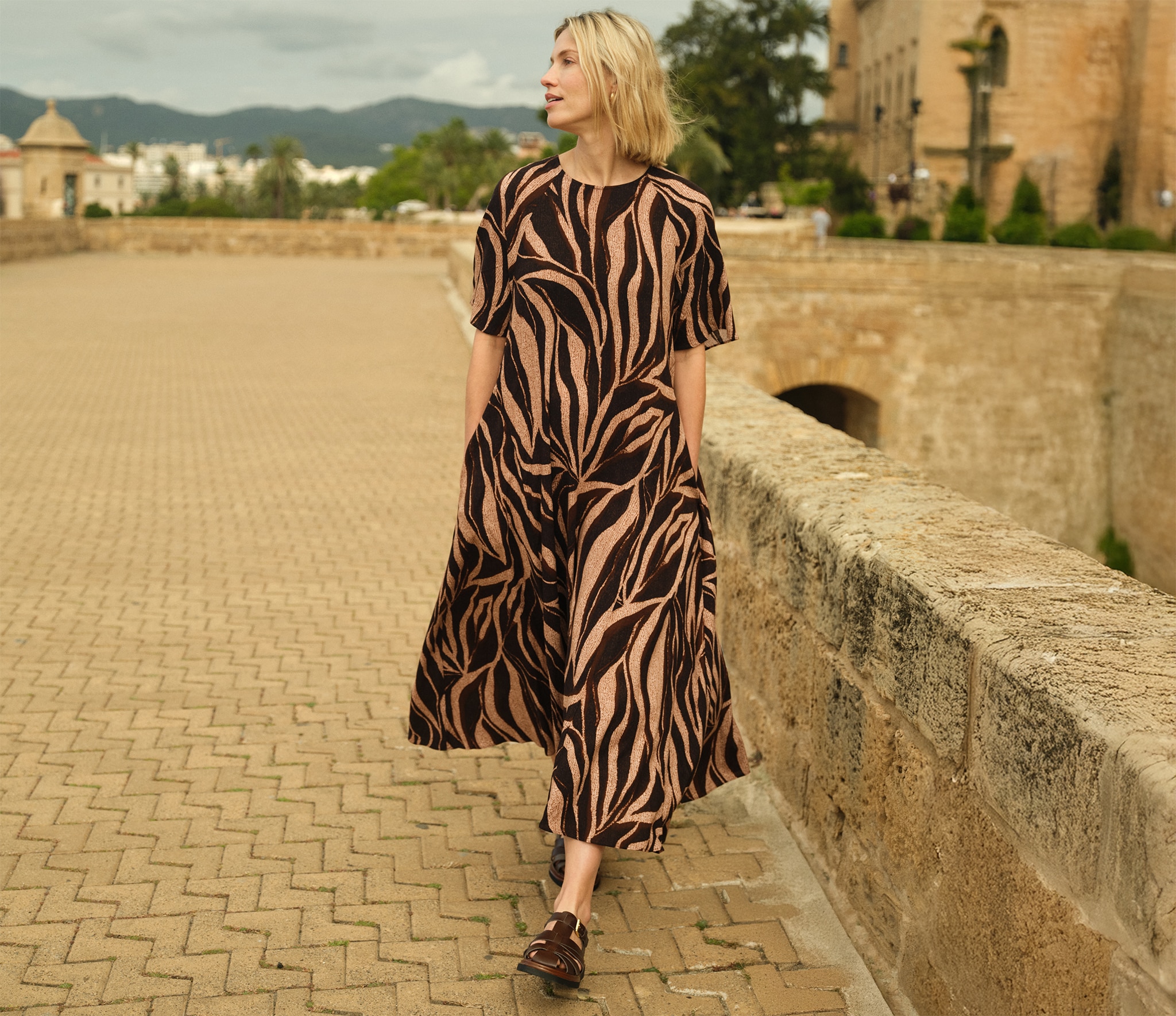Lady in a gold and black animal print dress walking