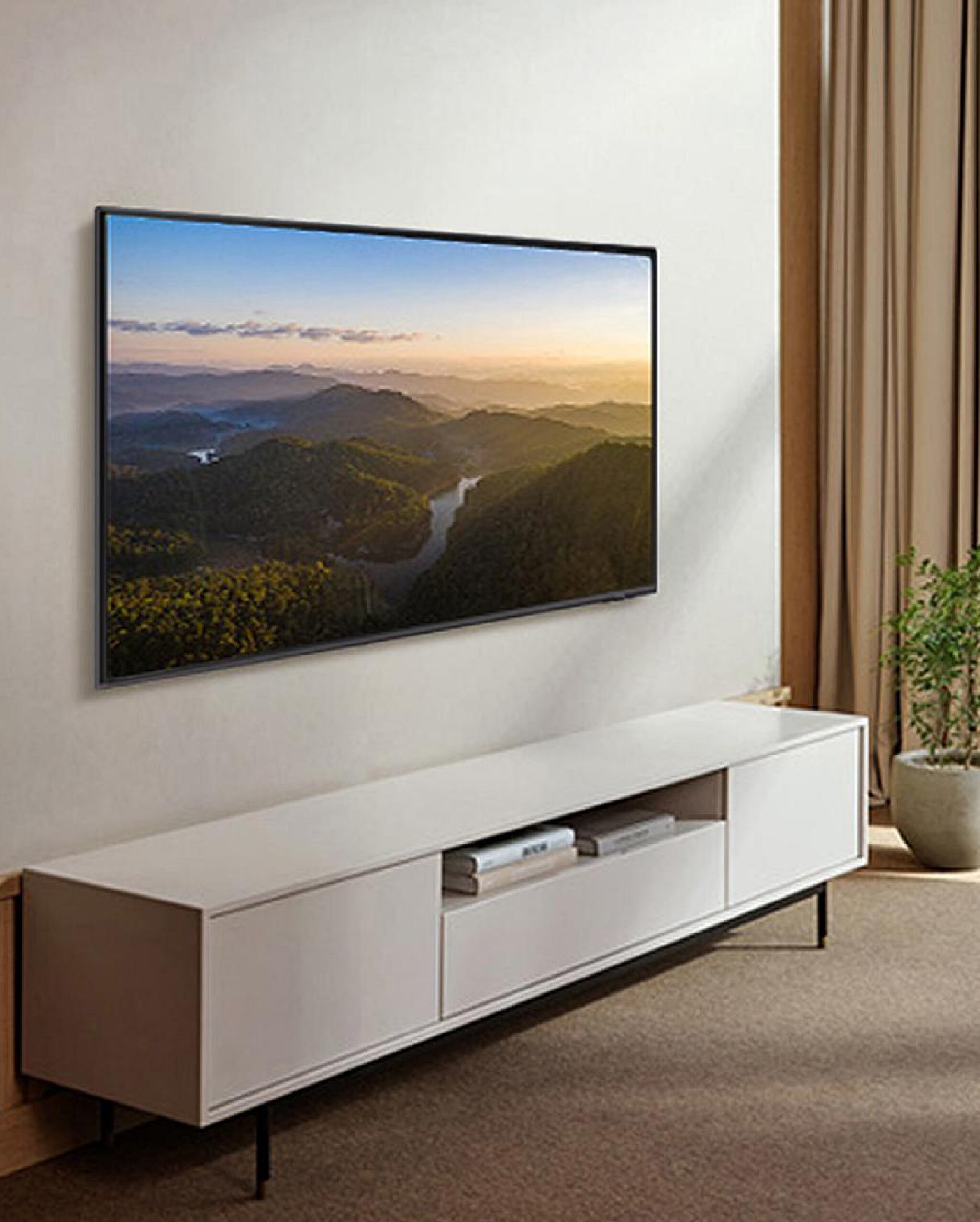 Large wall mounted flat screen  television with white unit underneath