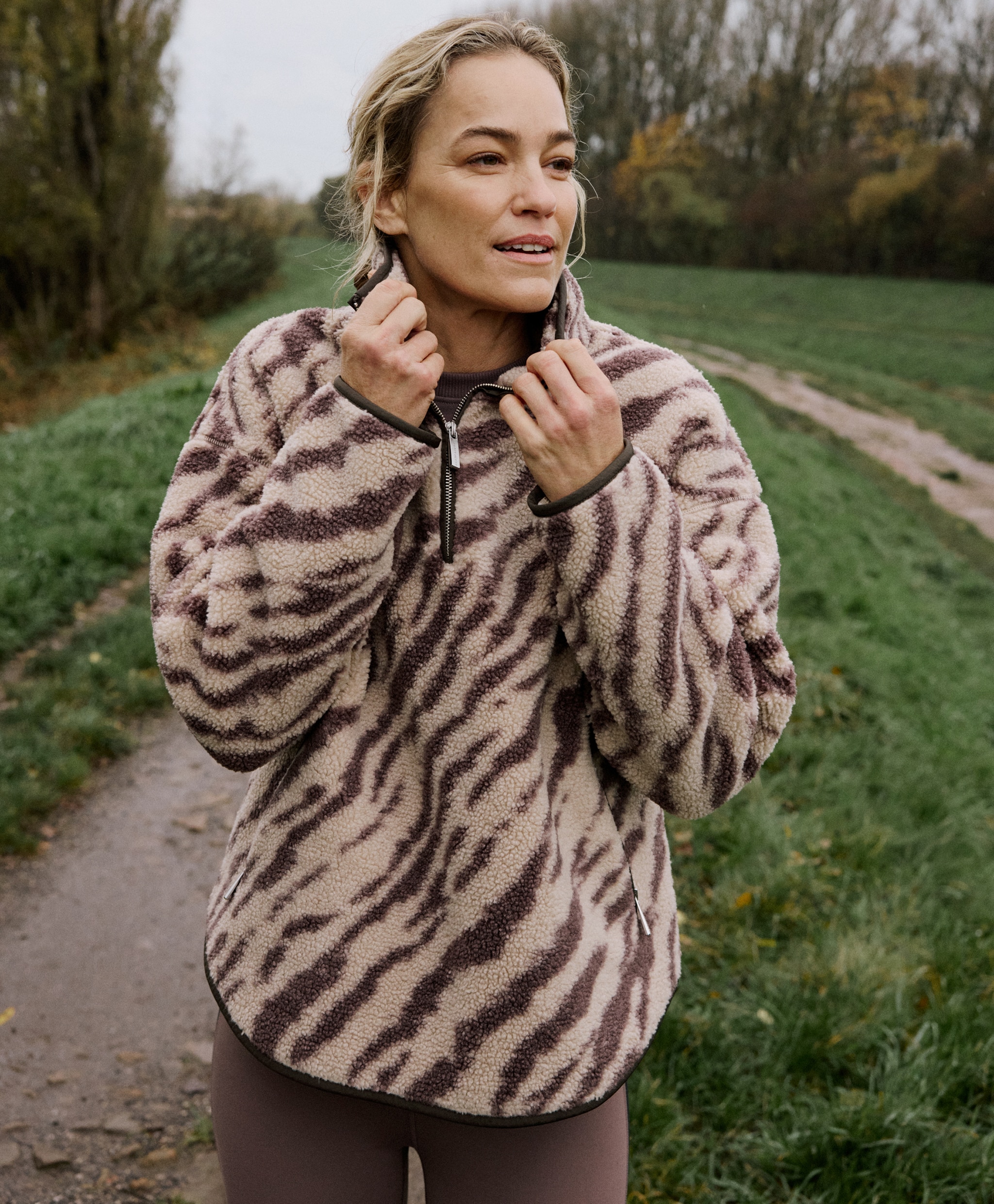 A lady outside wearing an animal printed fleece top.