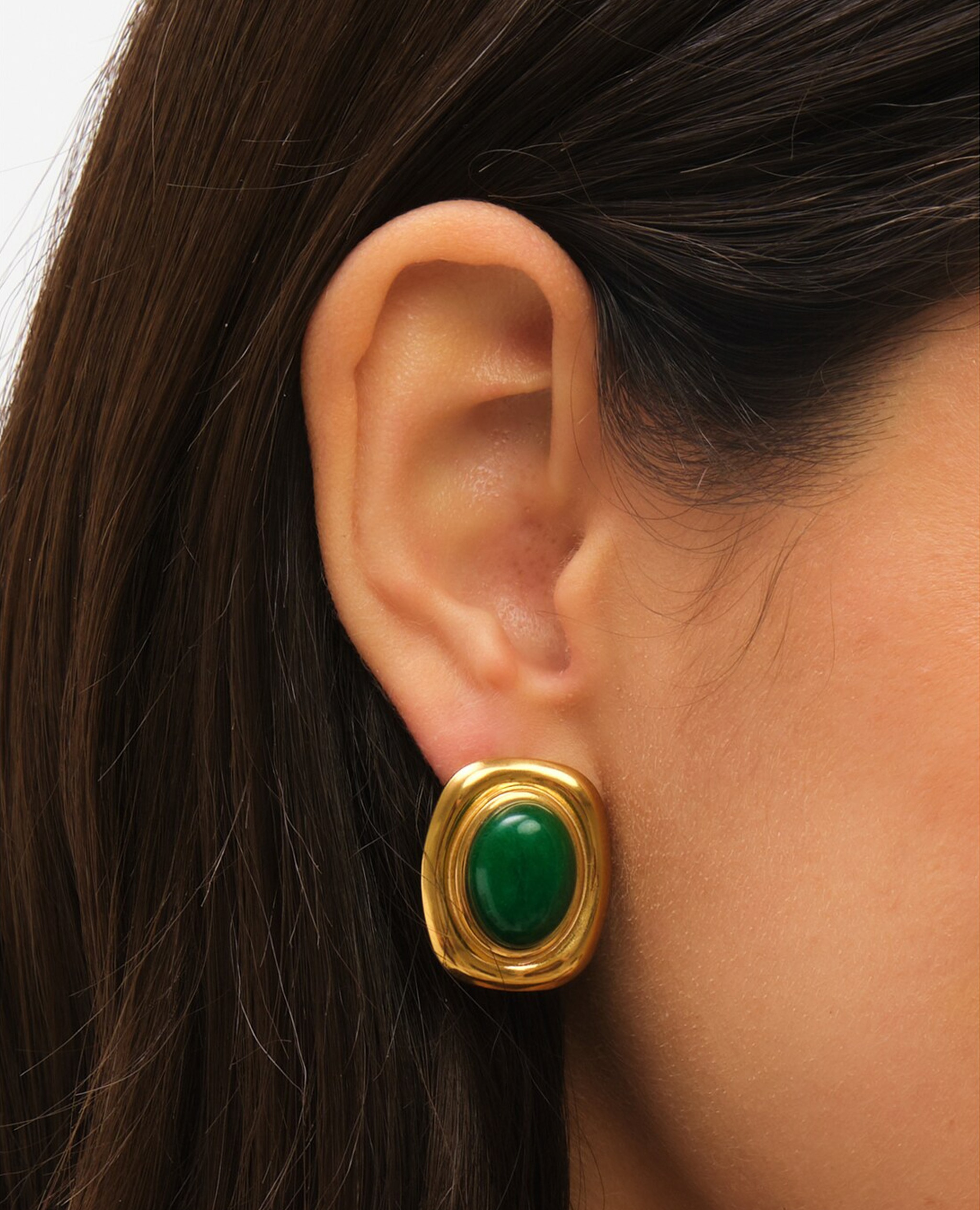 Model wearing gold and greeen statement earrings