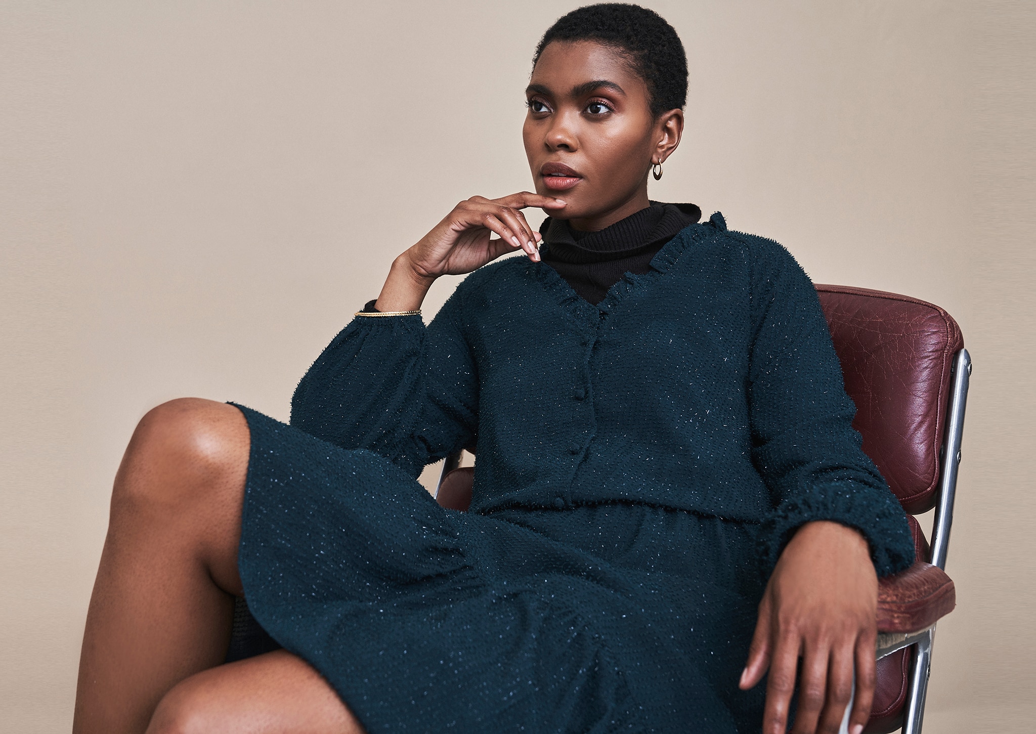 Woman sat in a chair wearing a black dress