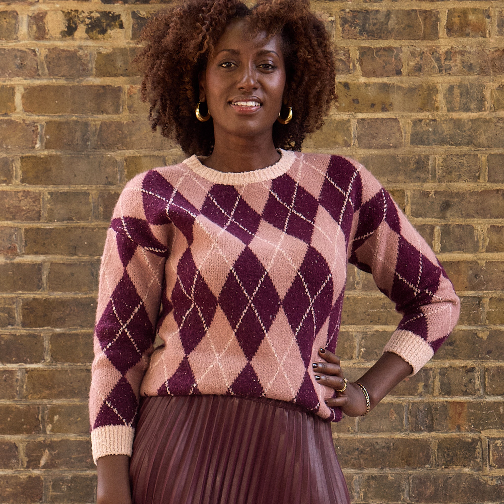 A lady wearing a pink and maroon fair isle patterned jumper