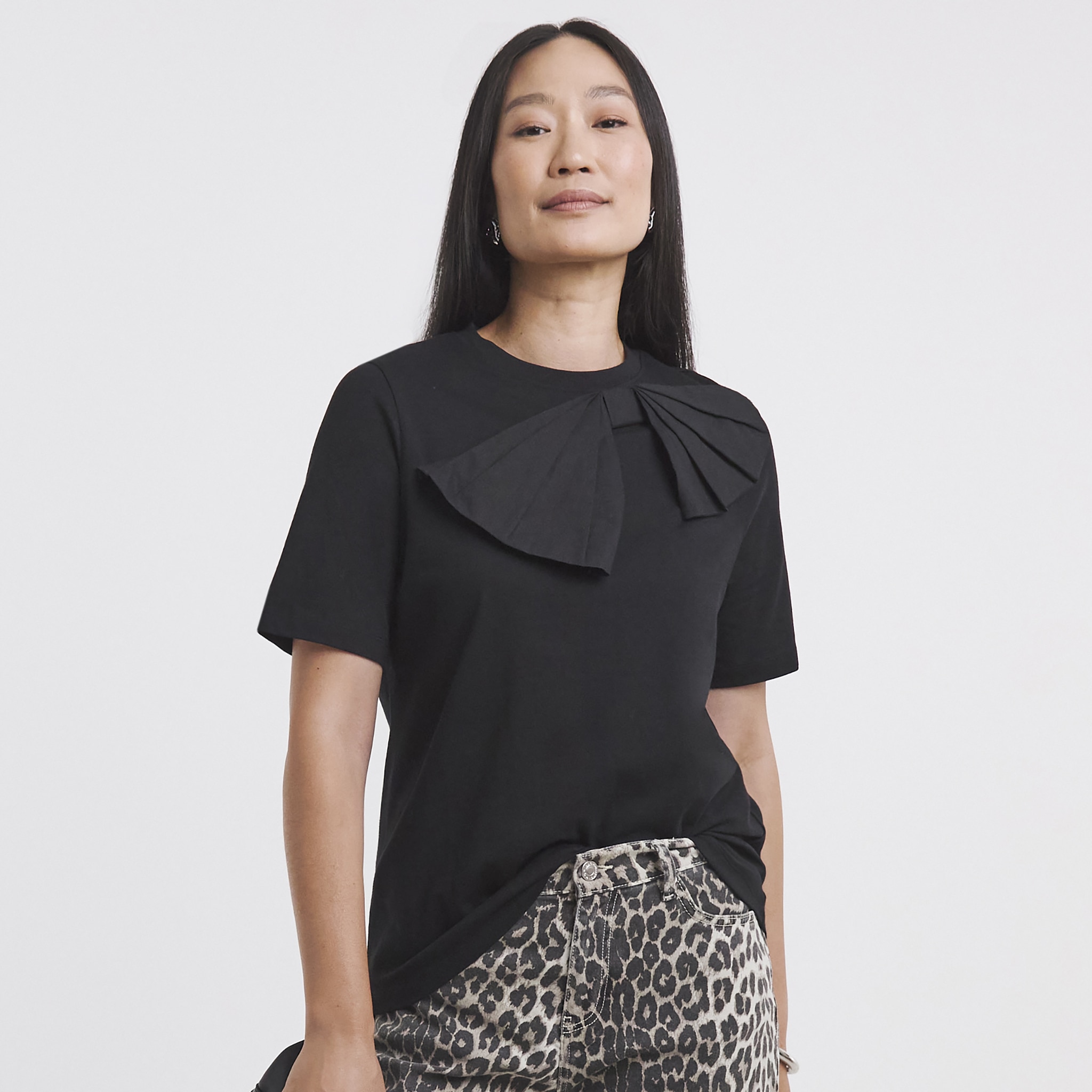 Lady wearing a black short sleeved top with bow detail on collar