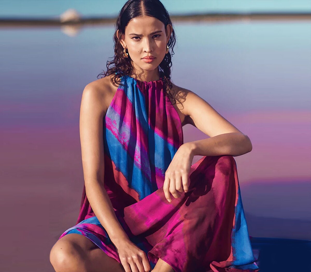 Woman sat wearing a purple and blue loose dress