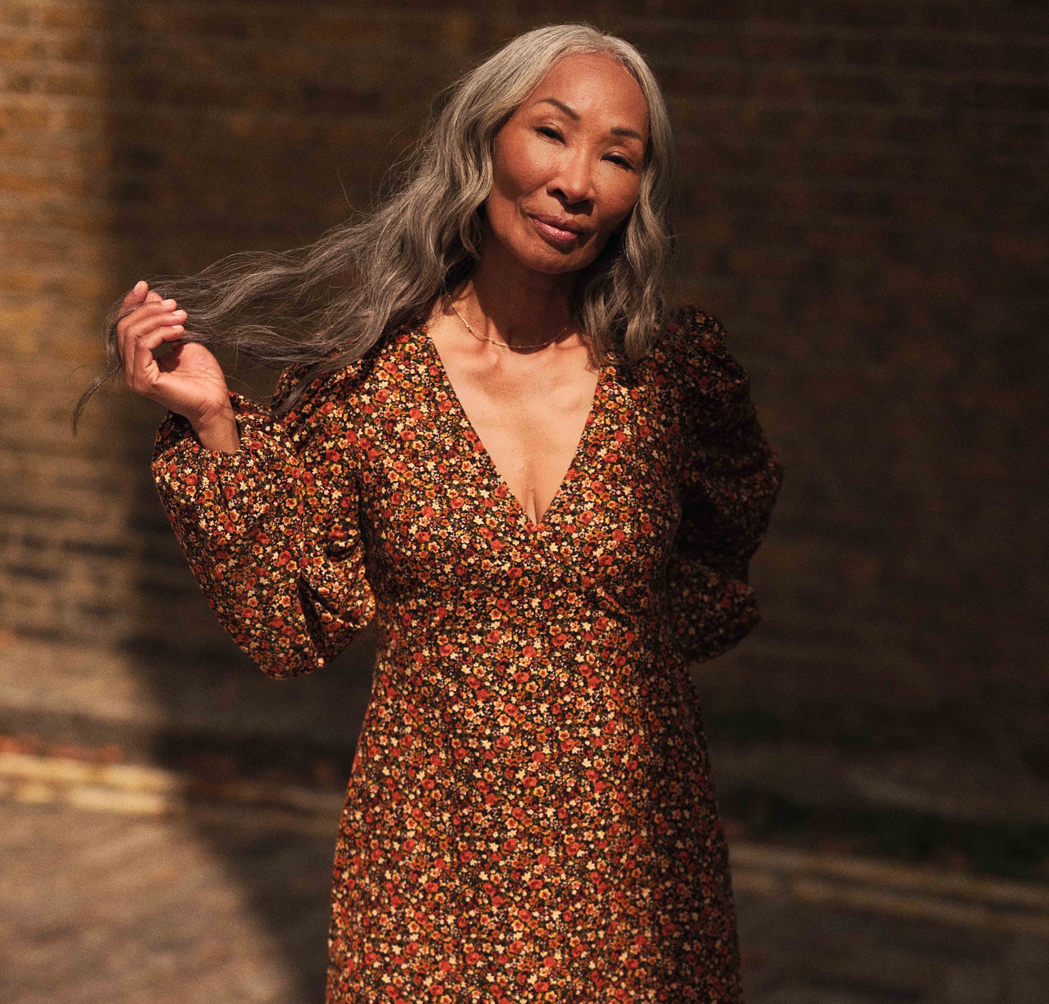 A lady wearing an orangey brown flower printed dress.