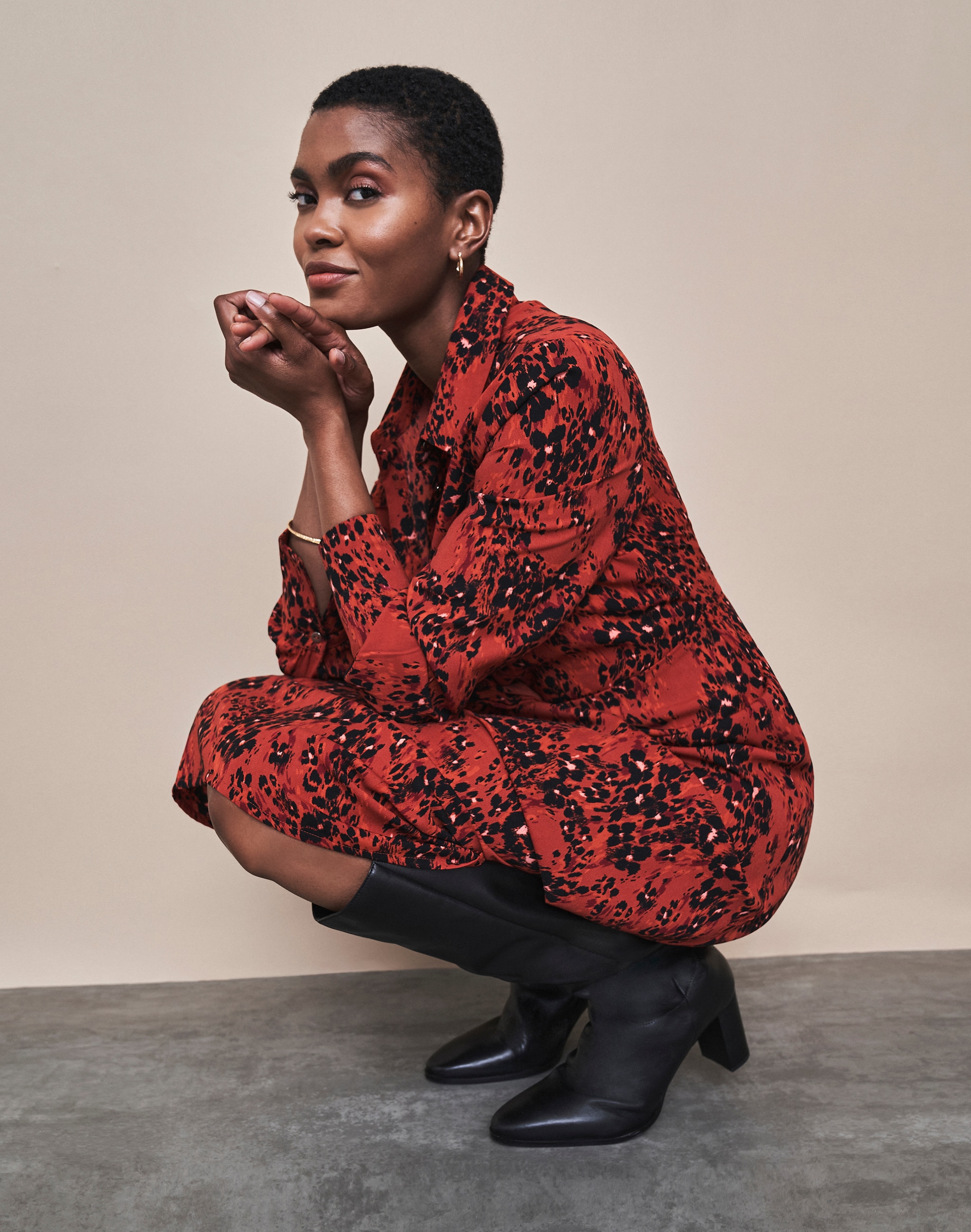 Woman crouched down wearing a red and black dress