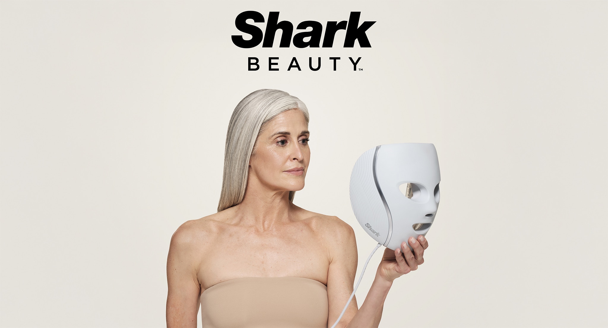 A lady holding a Shark Beauty mask