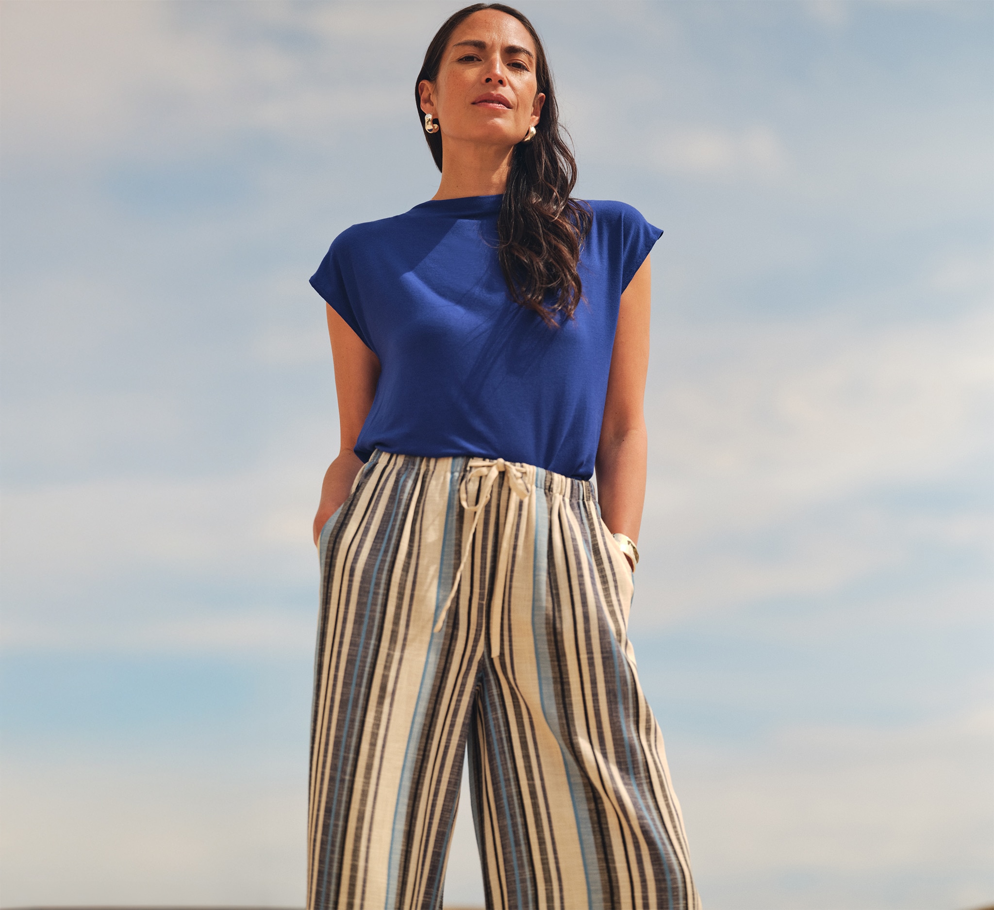 Lady wearing a blue top and stripey linen trousers