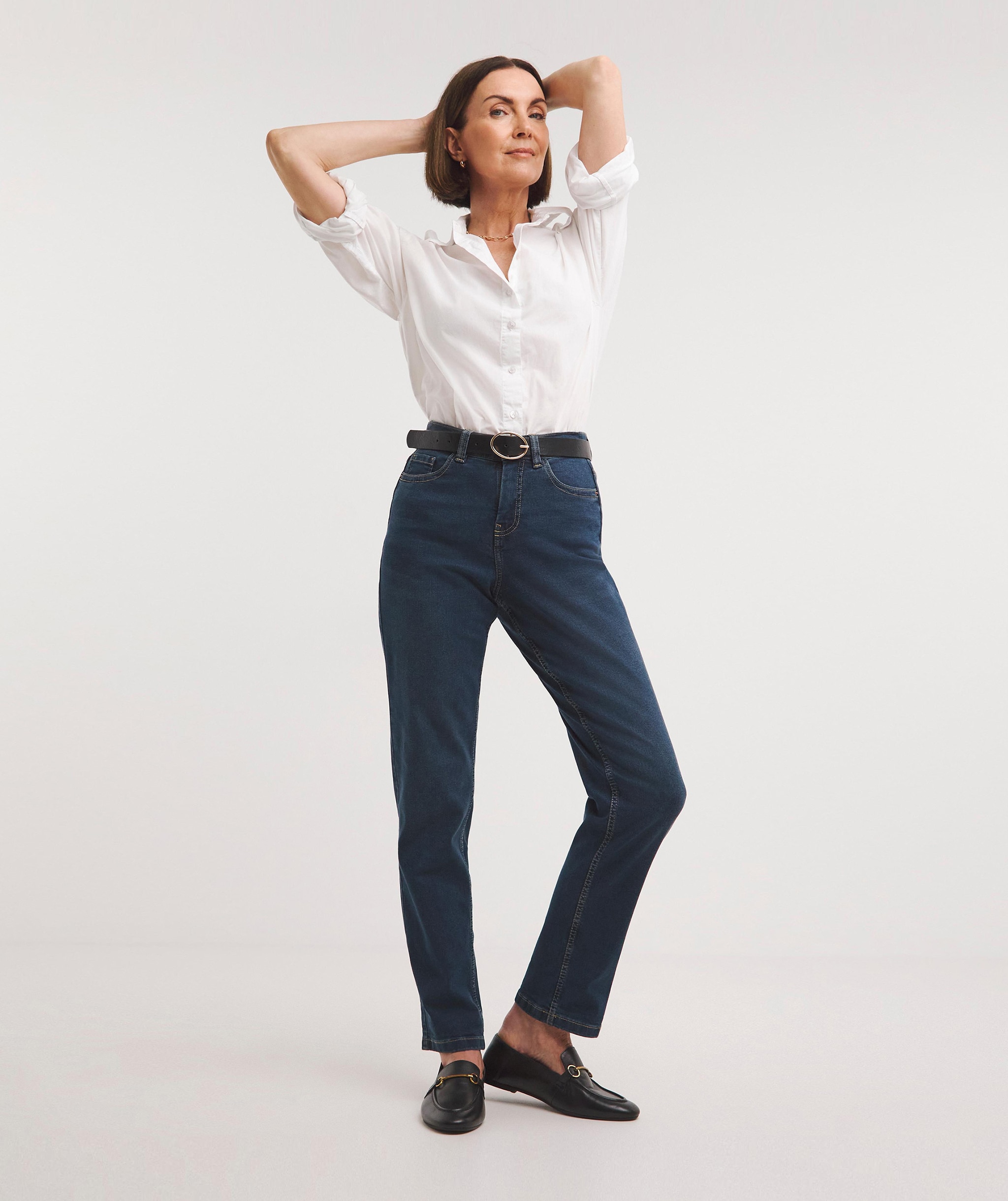 Woman wearing a dark blue boyfriend jeans and a white shirt
