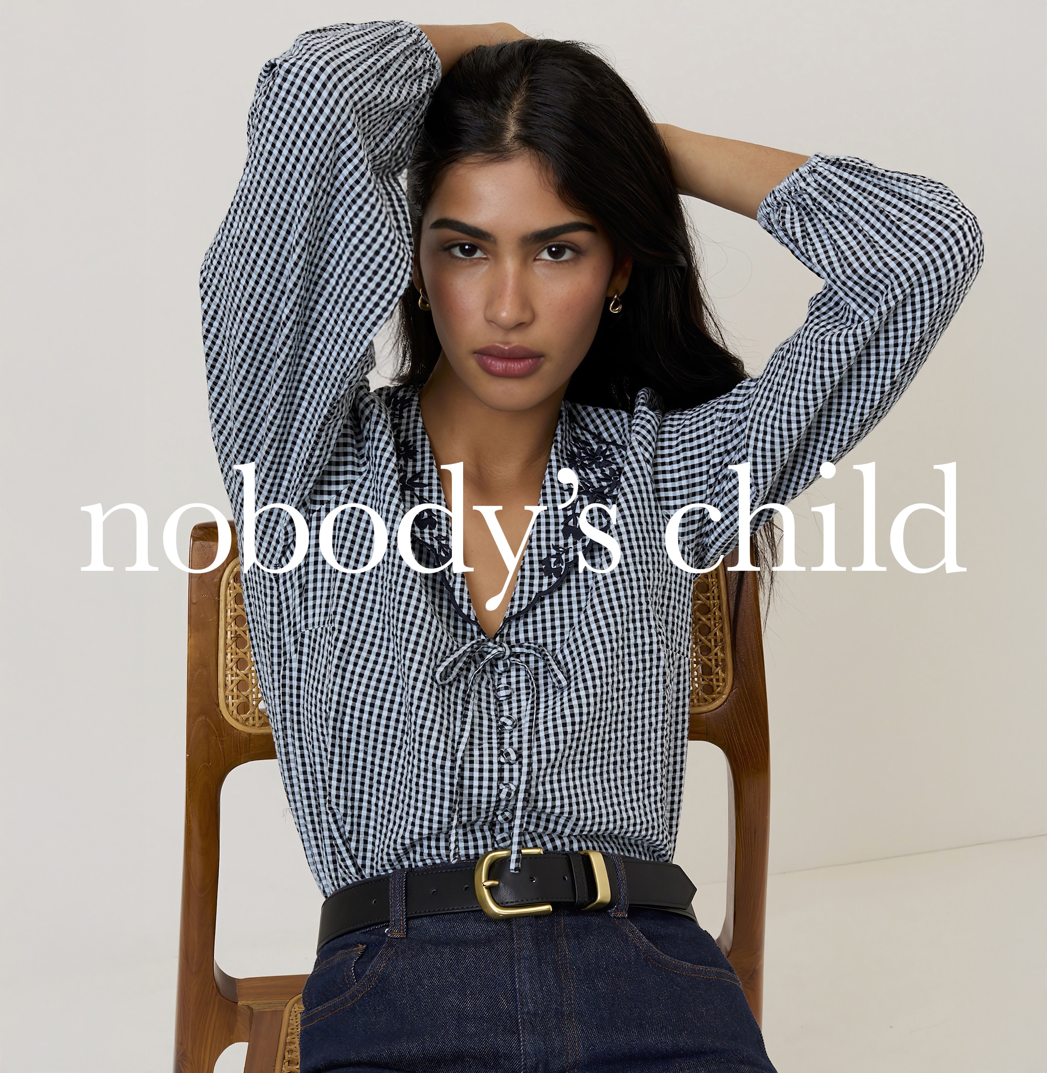 A lady wearing a navy blue and white gingham blouse