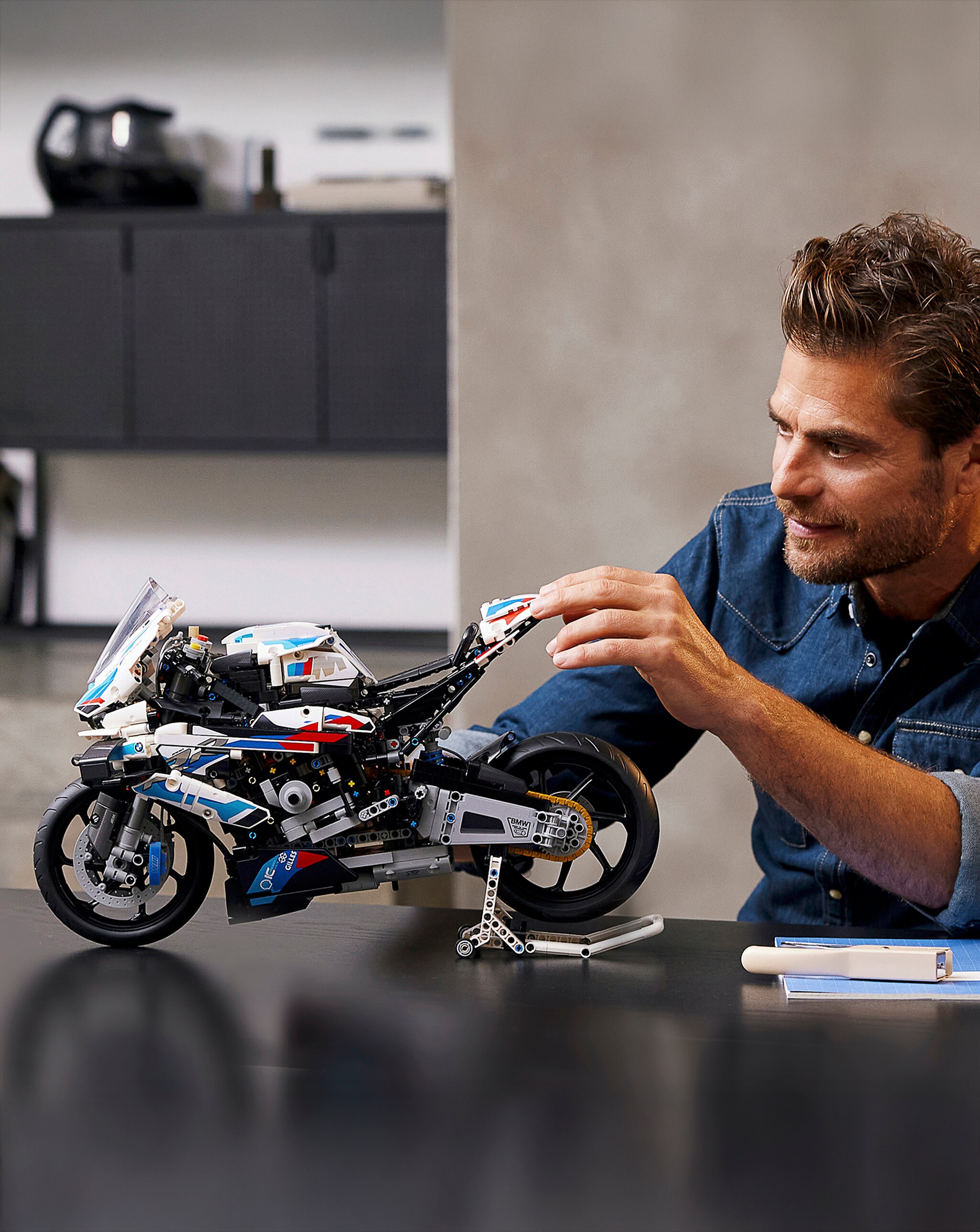 A man building with a LEGO® Technic motorbike