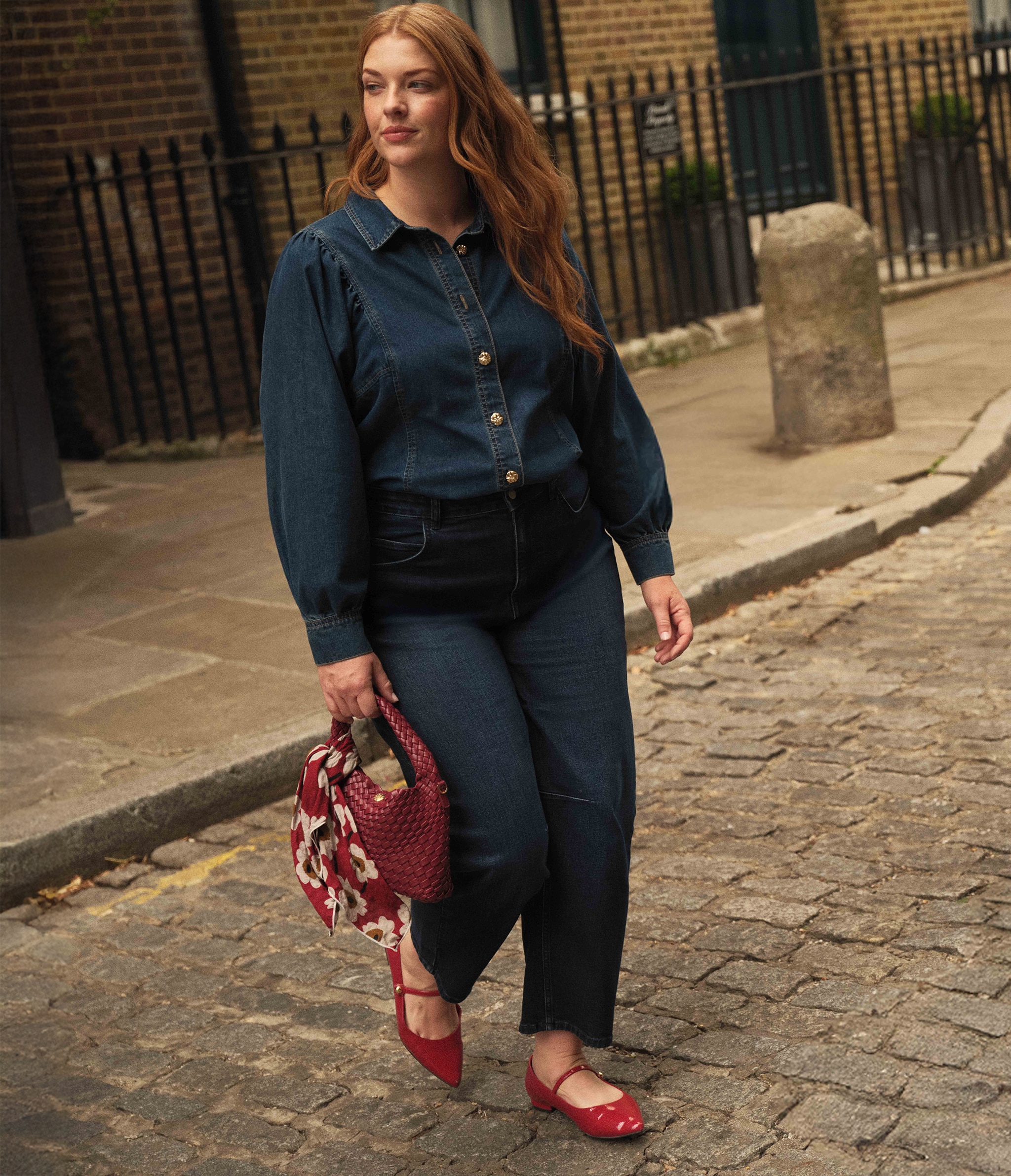 A lady wearing a denim shirt and jeans