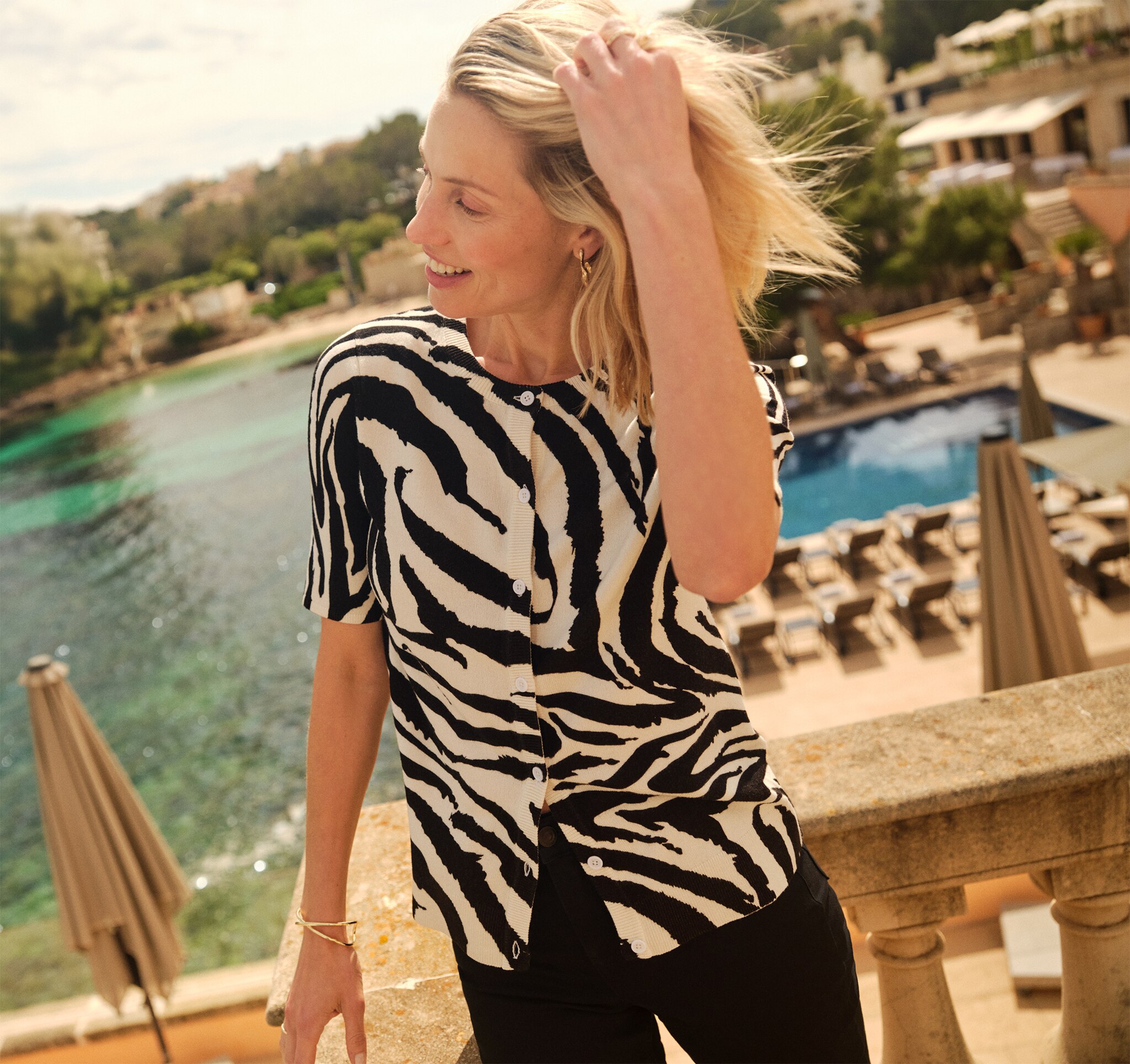A lady wearing a black and white animal print top stood by the sea