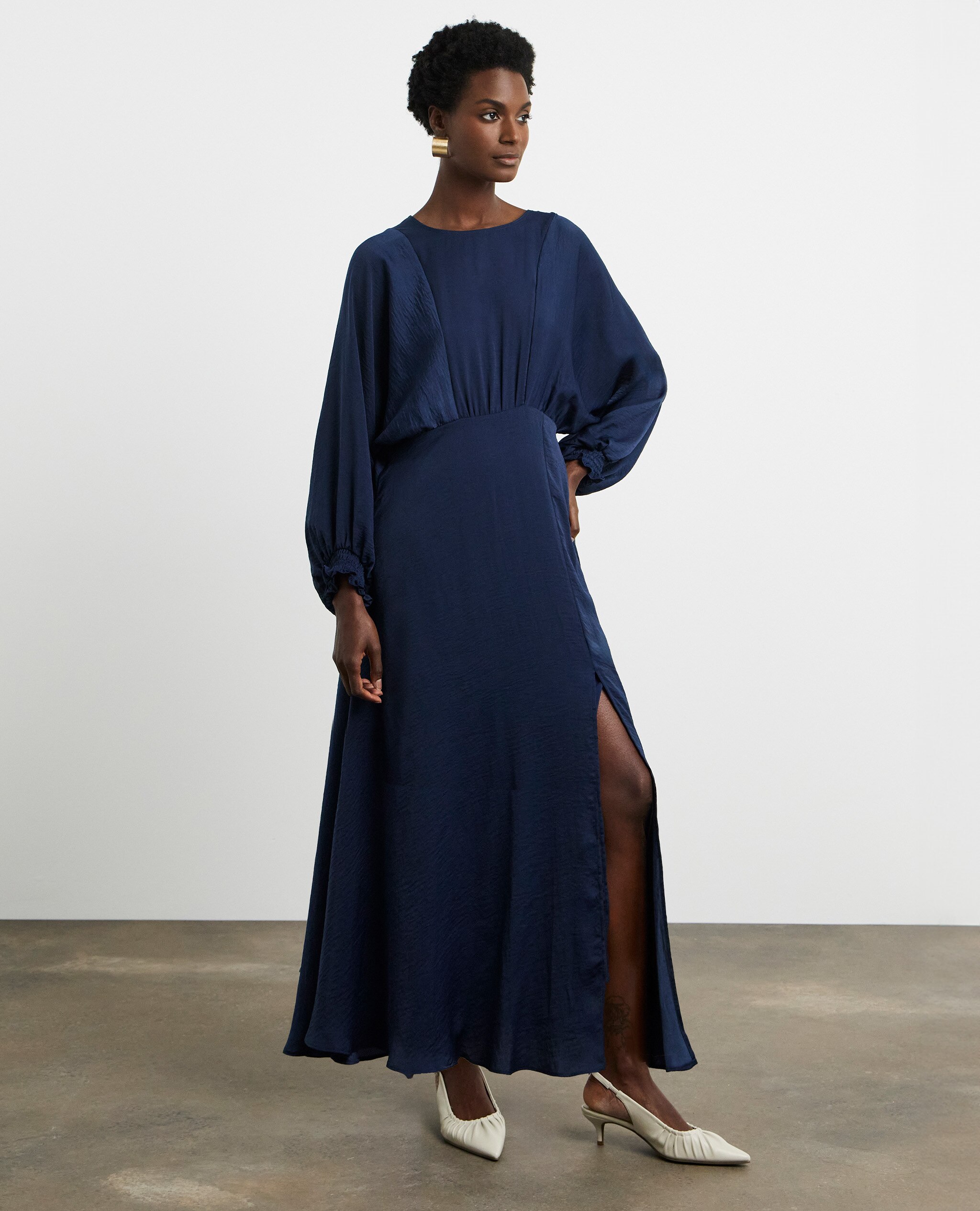 Model wearing a navy full-coverage long sleeve maxi dress with a high-slit