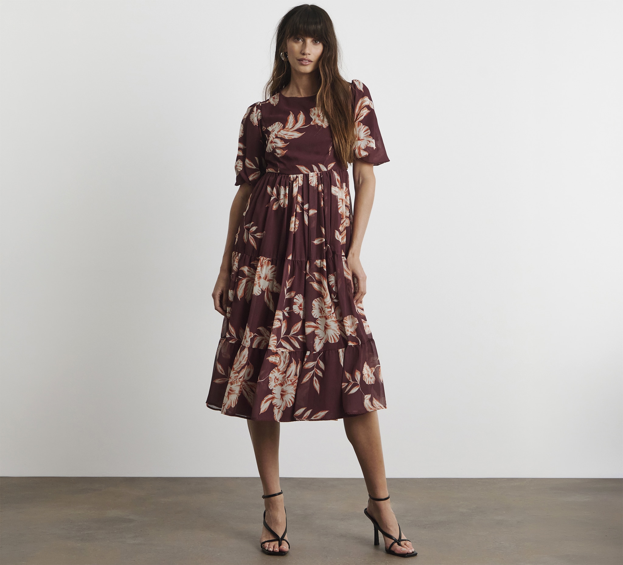 A lady wearing a Joanna Hope lace back midi dress.