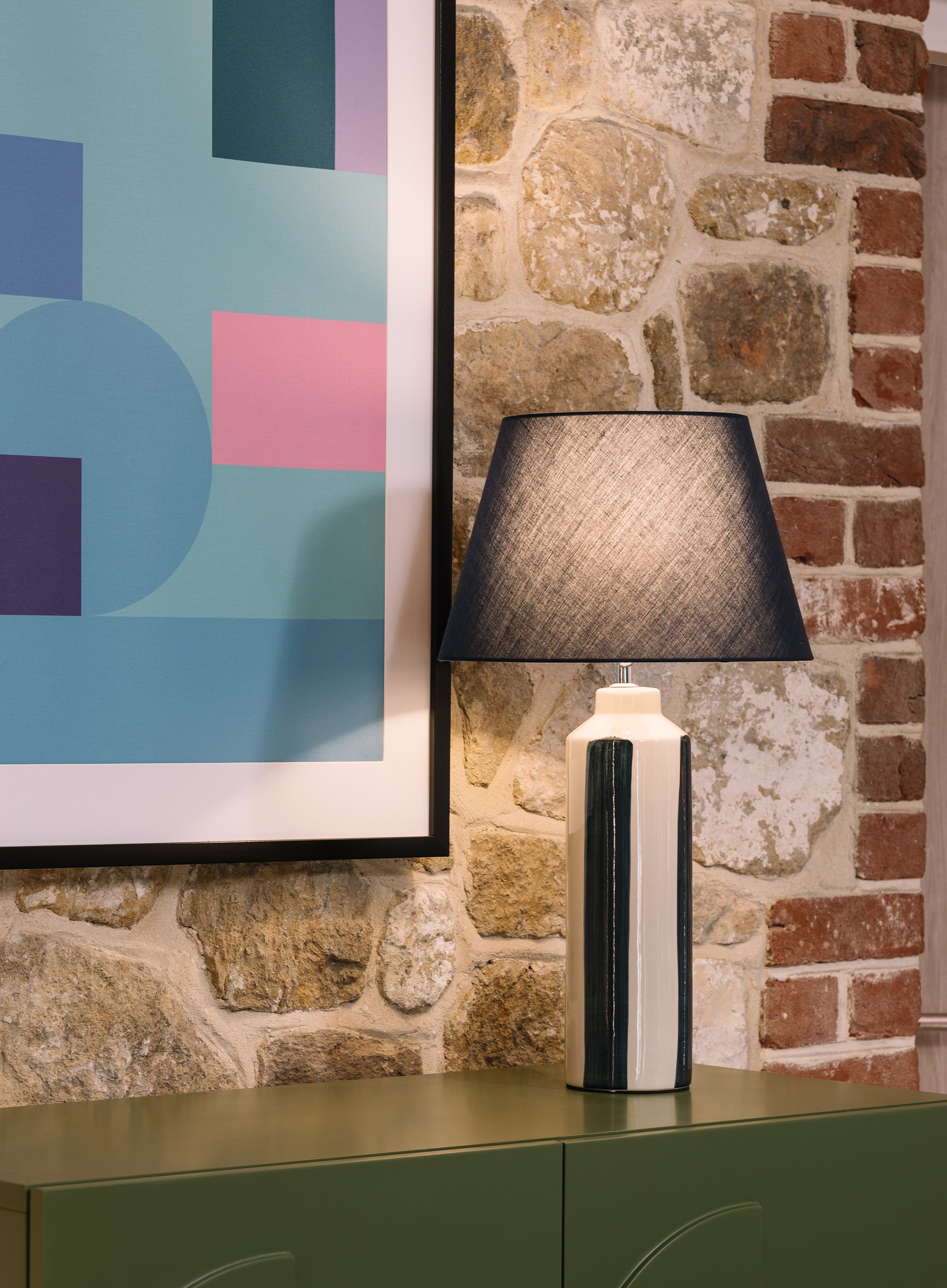 A lamp on a sideboard