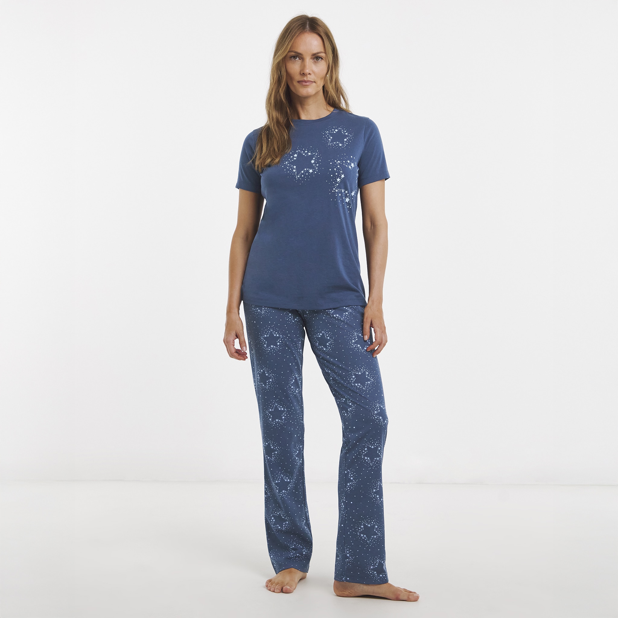 A lady wearing a navy blue pyjama lounge suit.