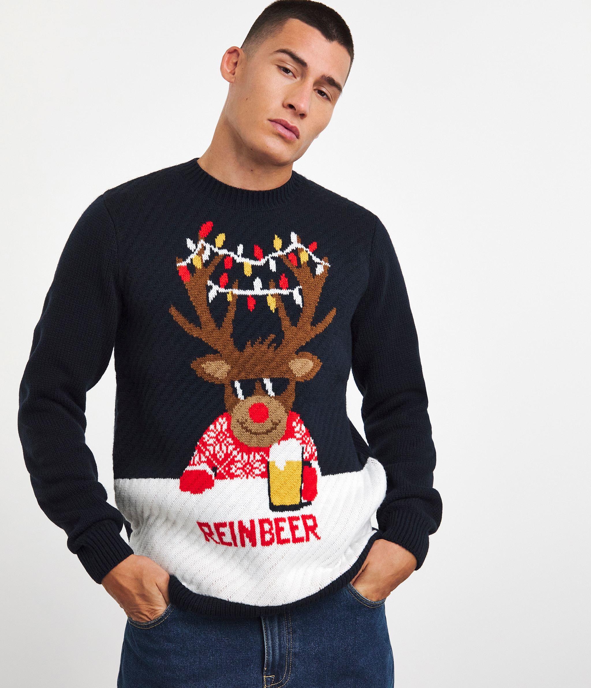 A man wearing a navy blue novelty reinbeer Christmas jumper.