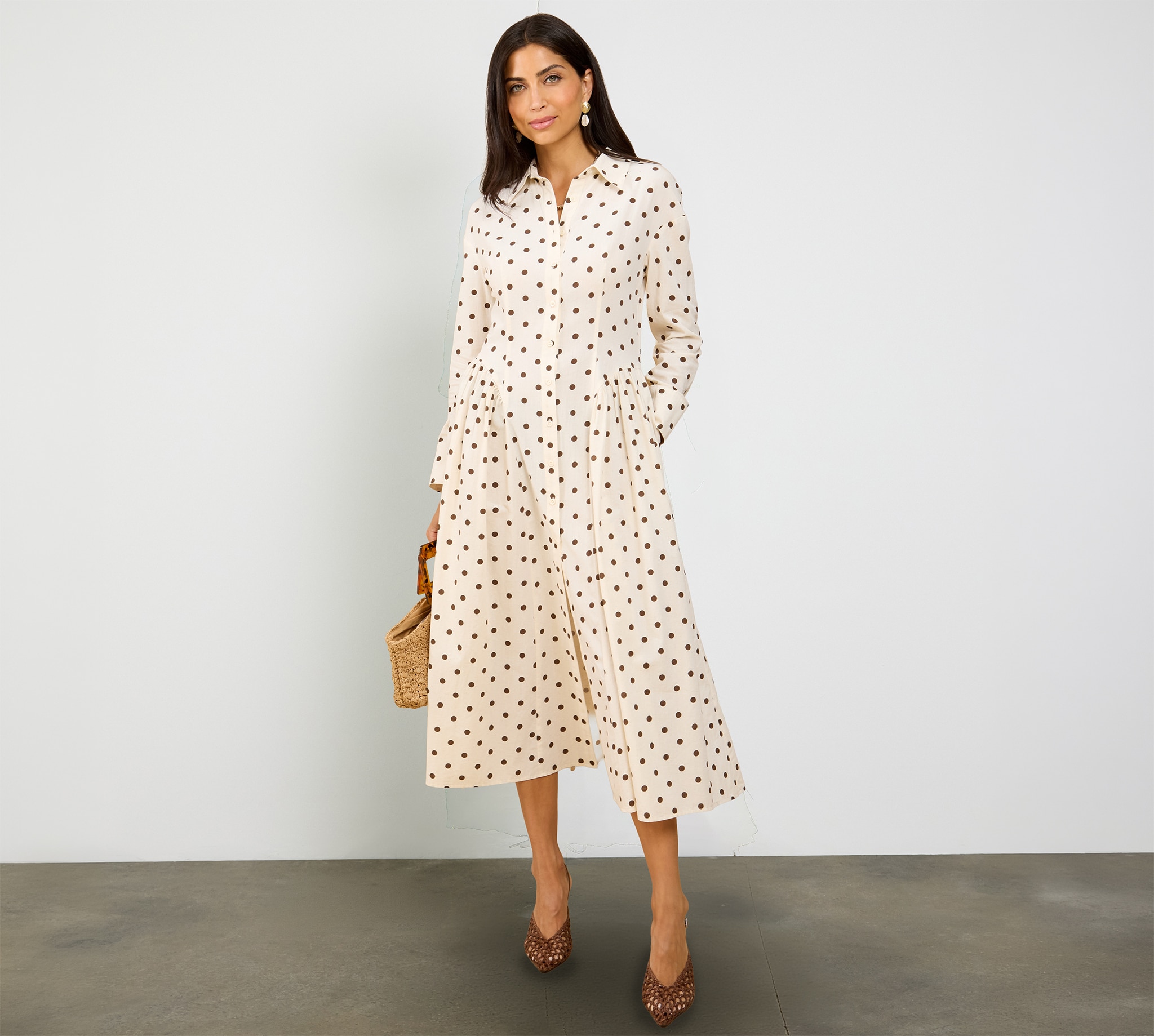 A lady wearing a cream polka dot midaxi shirt dress.