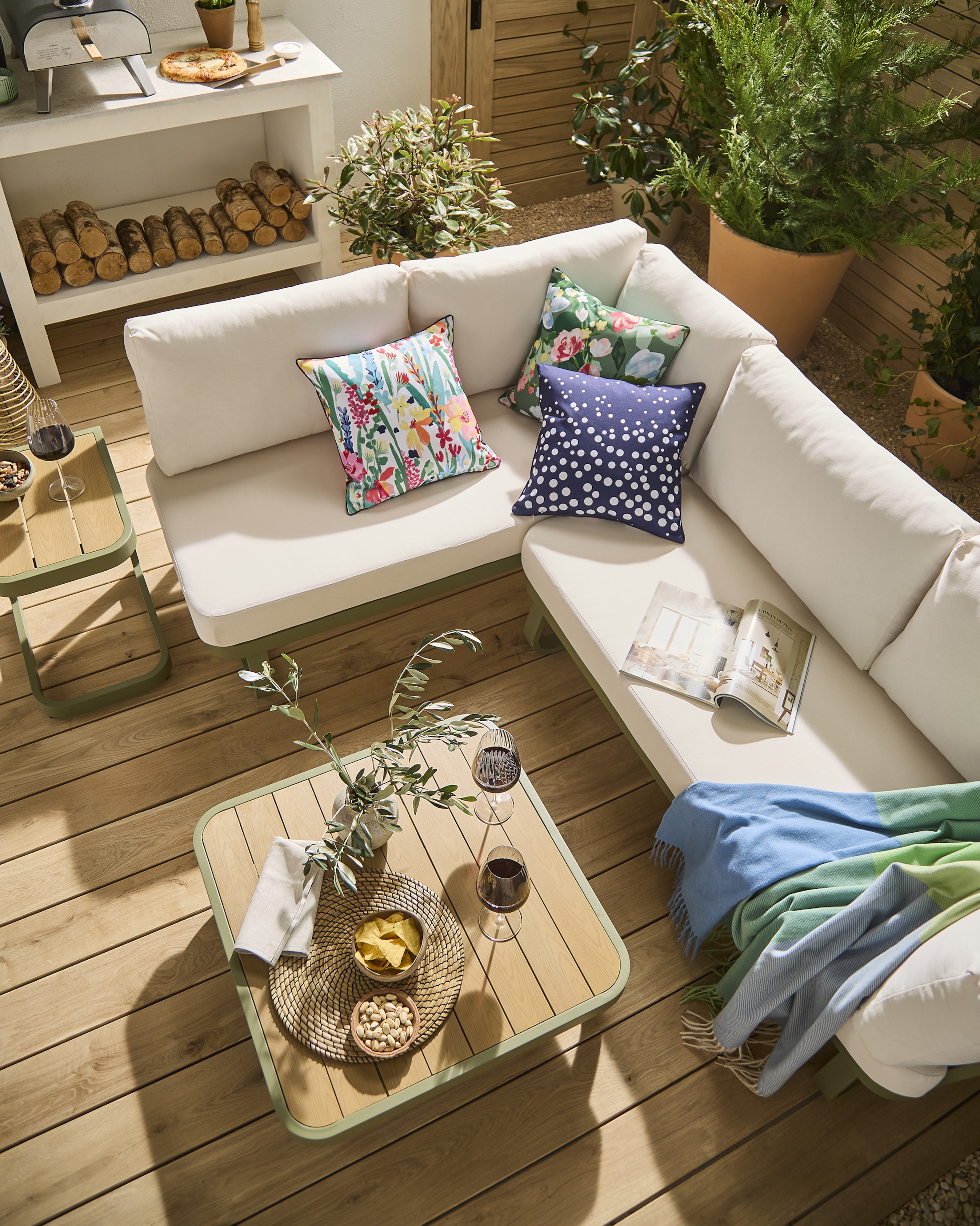 An outside scene of a garden. There's an L shape garden sofa.