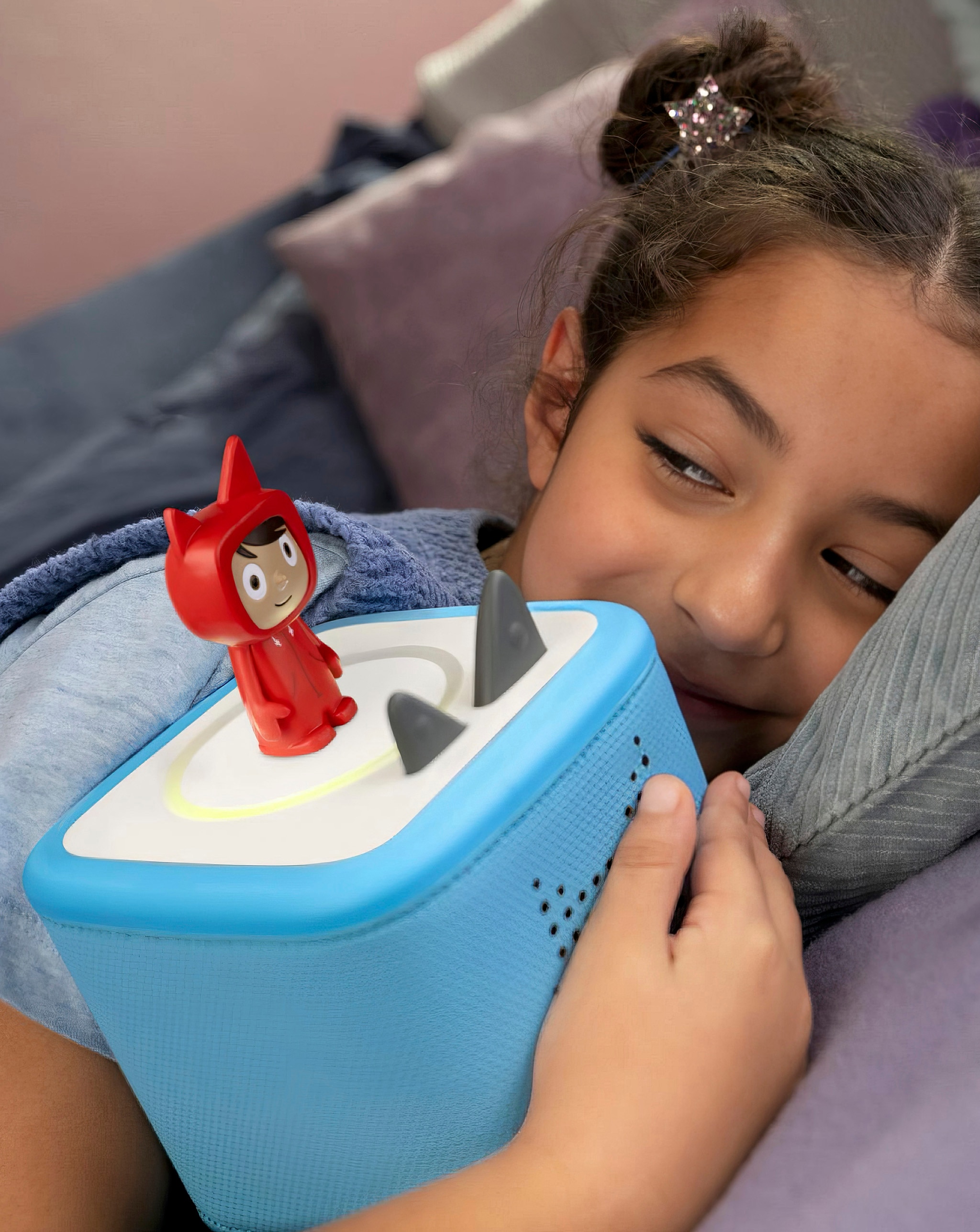 Child hugging a tonies device