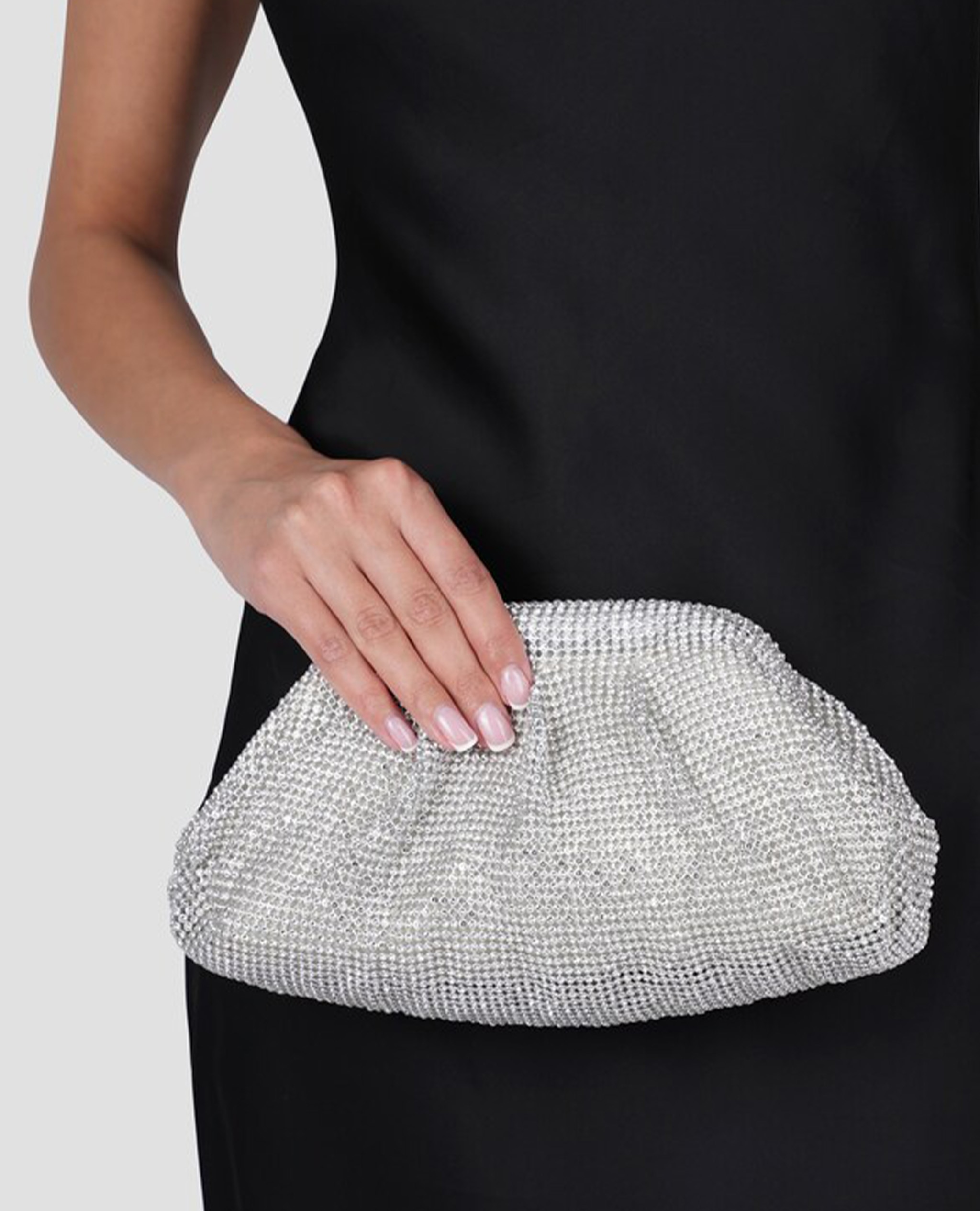 Model holding silver clutch bag