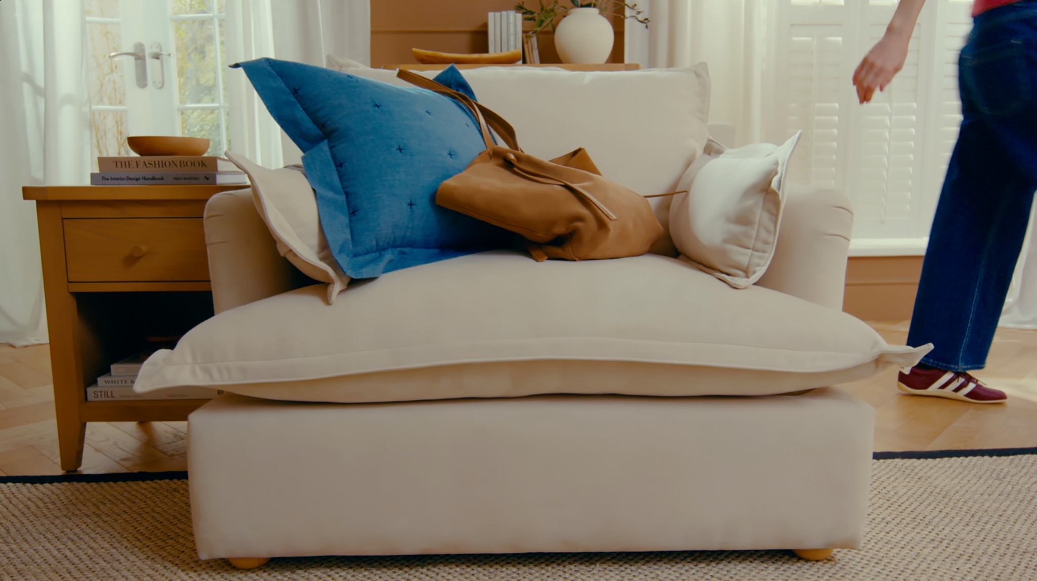 A living room scene with a brown dropped on a beige sofa.