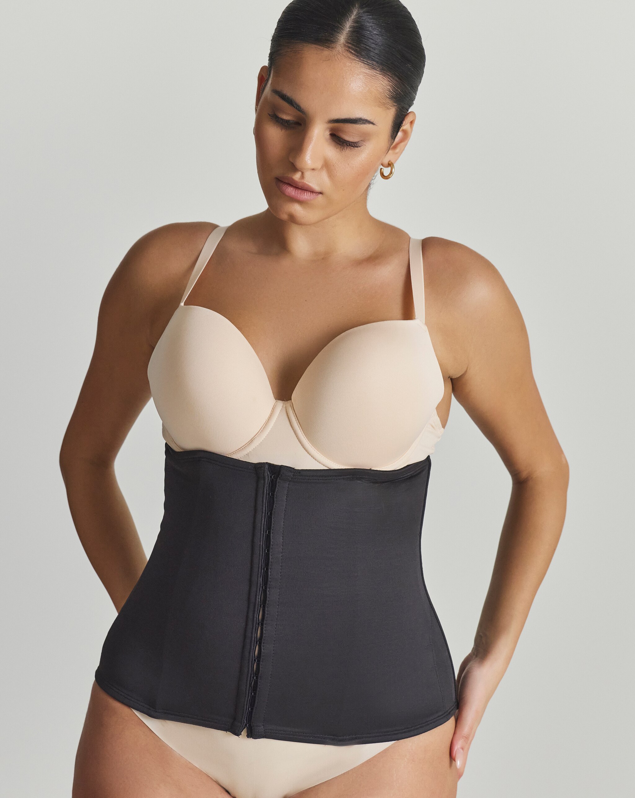 A lady wearing a Miraclesuit Classic Firm Control Waist Cincher