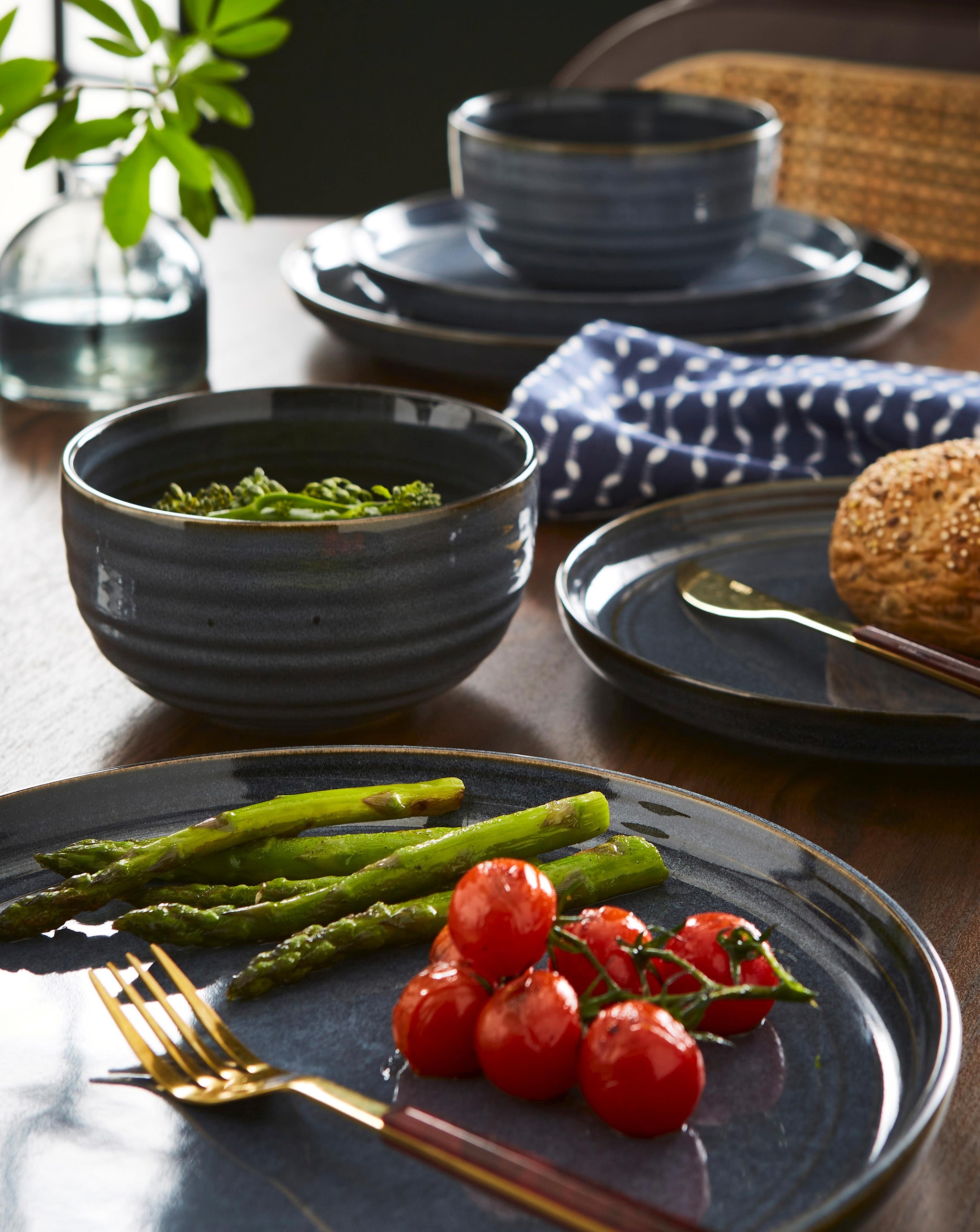 A kitchen table with dinner set and food