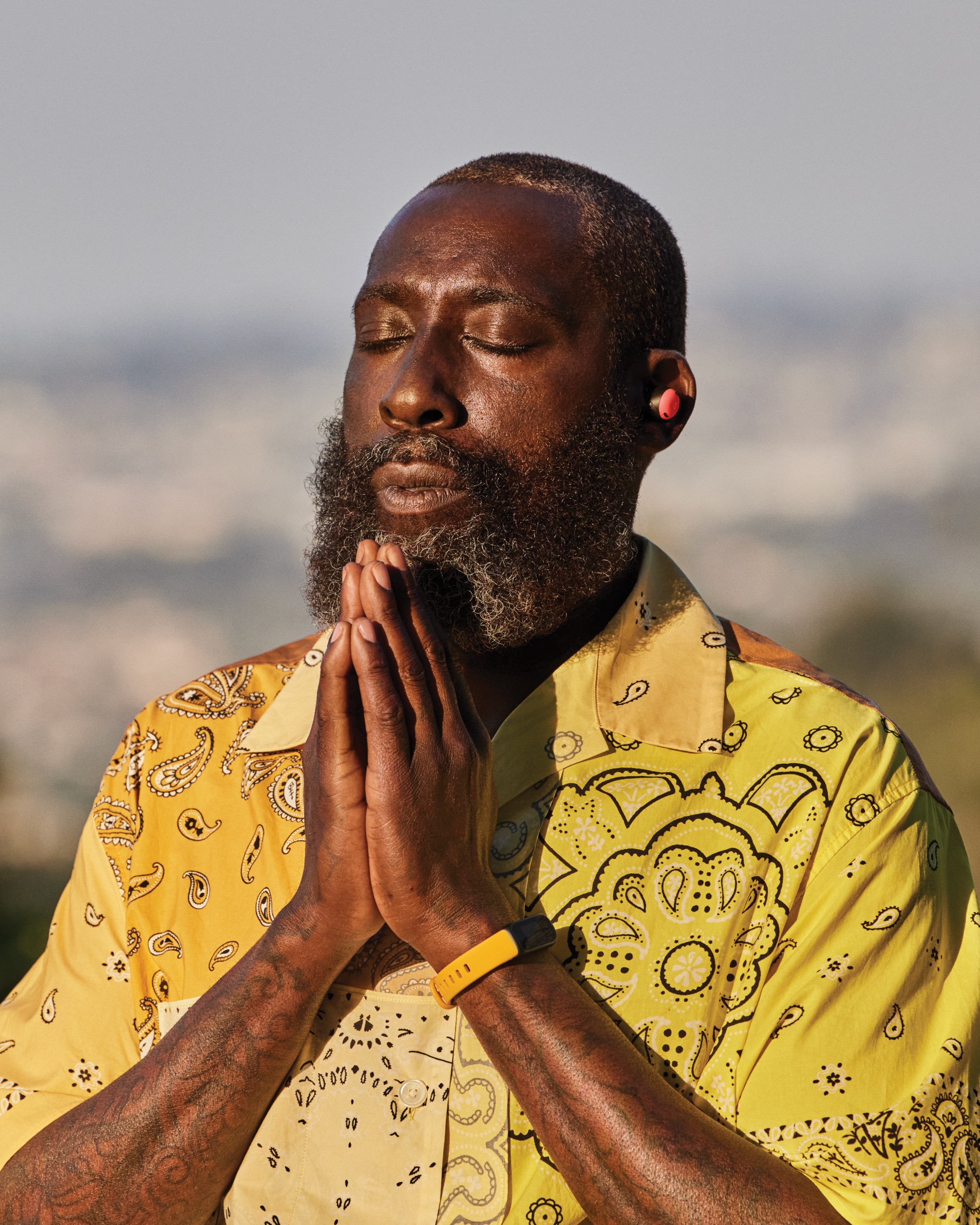 A man meditating wearing his fitbit watch