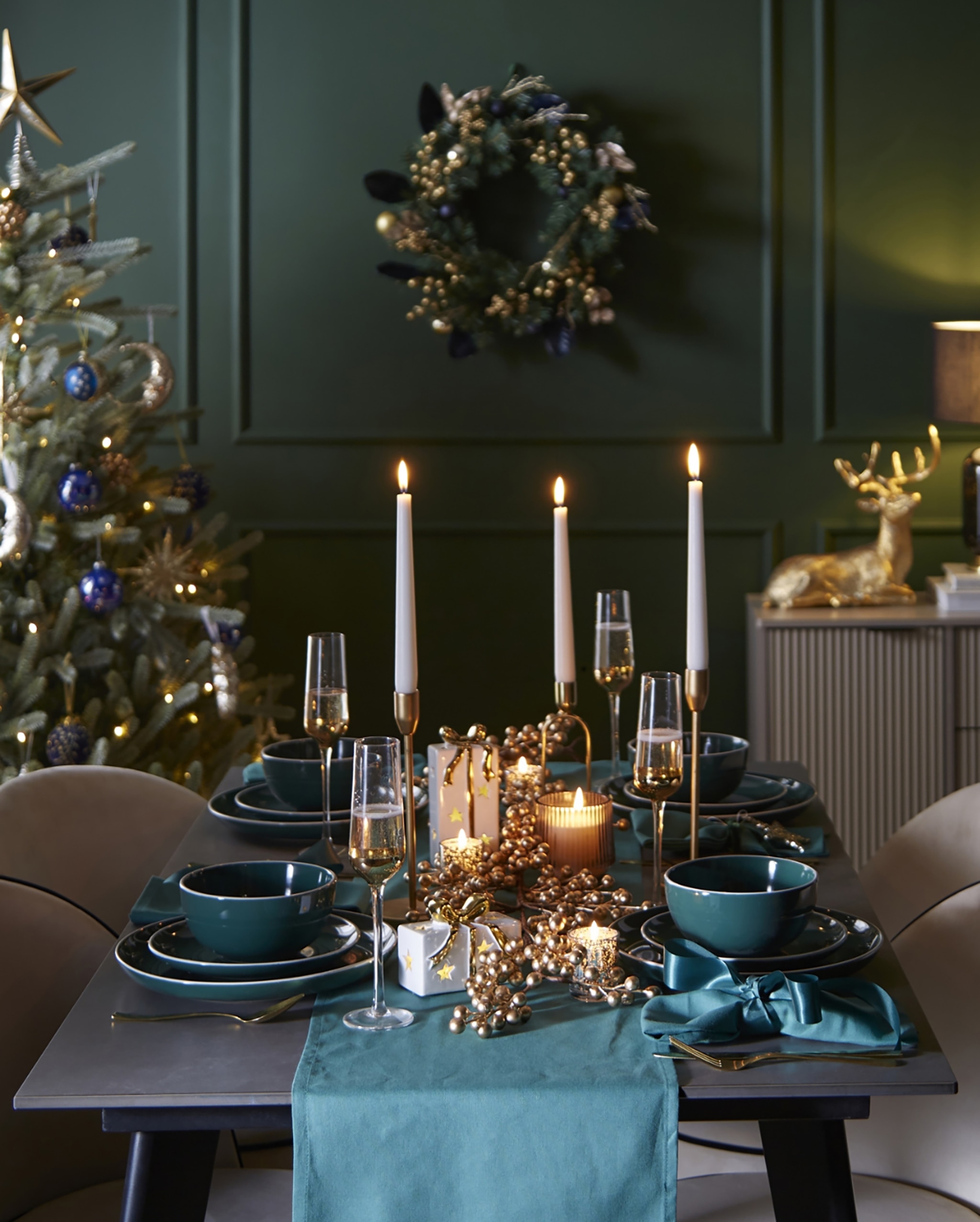 Elegant Teal Table Setting For Christmas Dinner With Candles, Tree, And Wreath Decor
