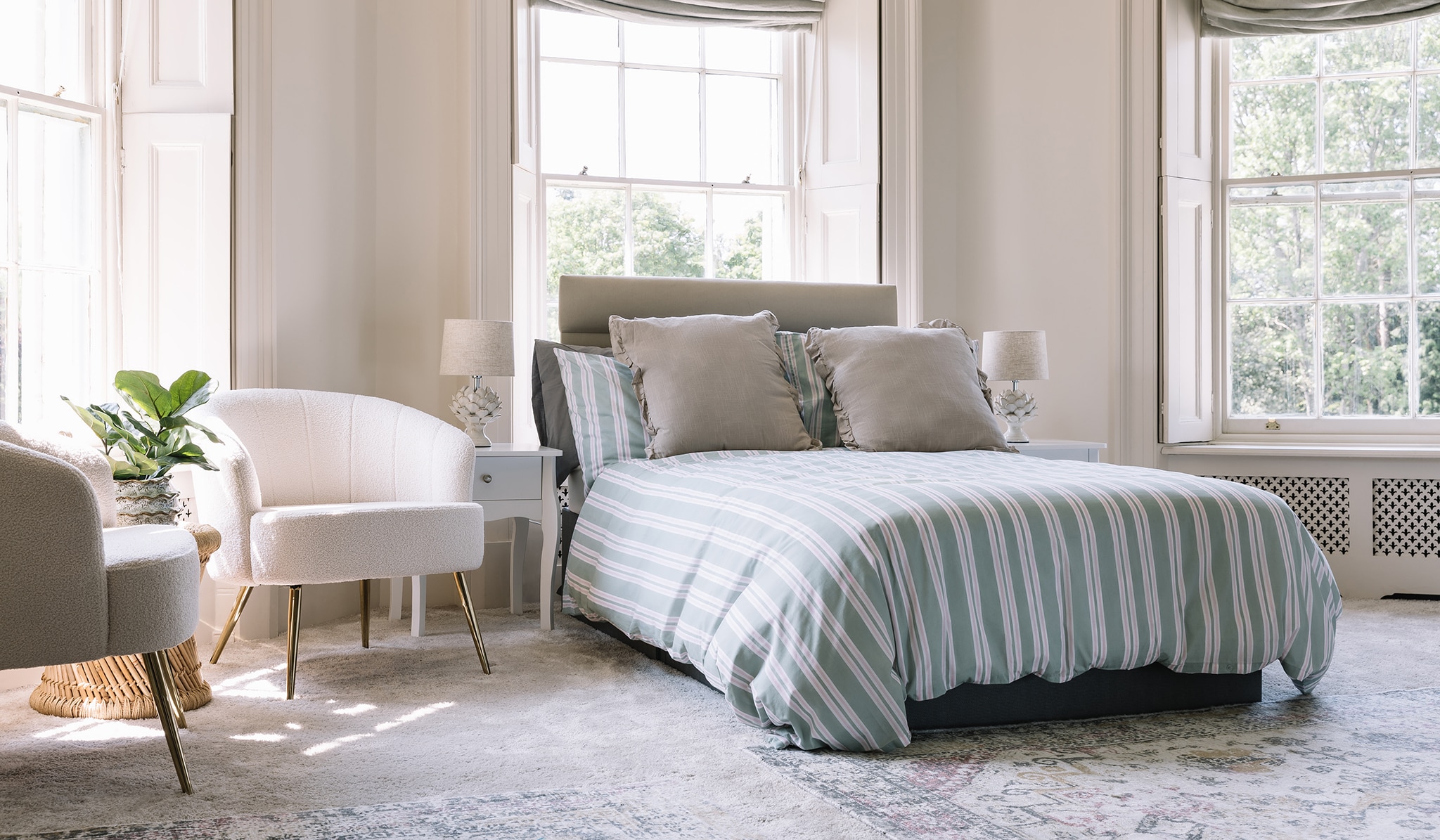 A bedroom with double bed and stripy duvet set